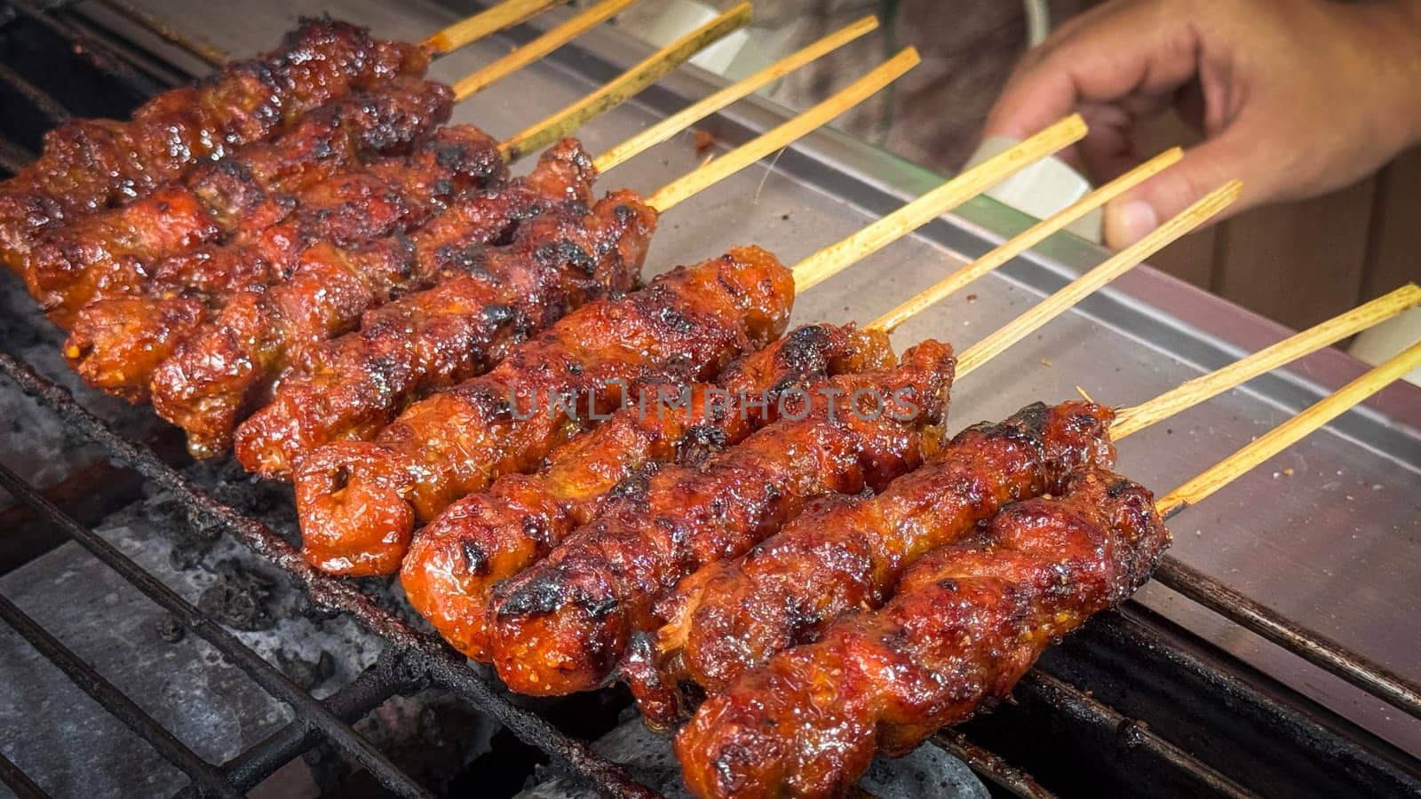 skewered beef meat on a grill, or barbecue bbq, locals called it beef satay showcasing their vibrant glaze and texture. Perfect representation of barbecue culture, grilling cuisine, and outdoor cooking enjoyment.