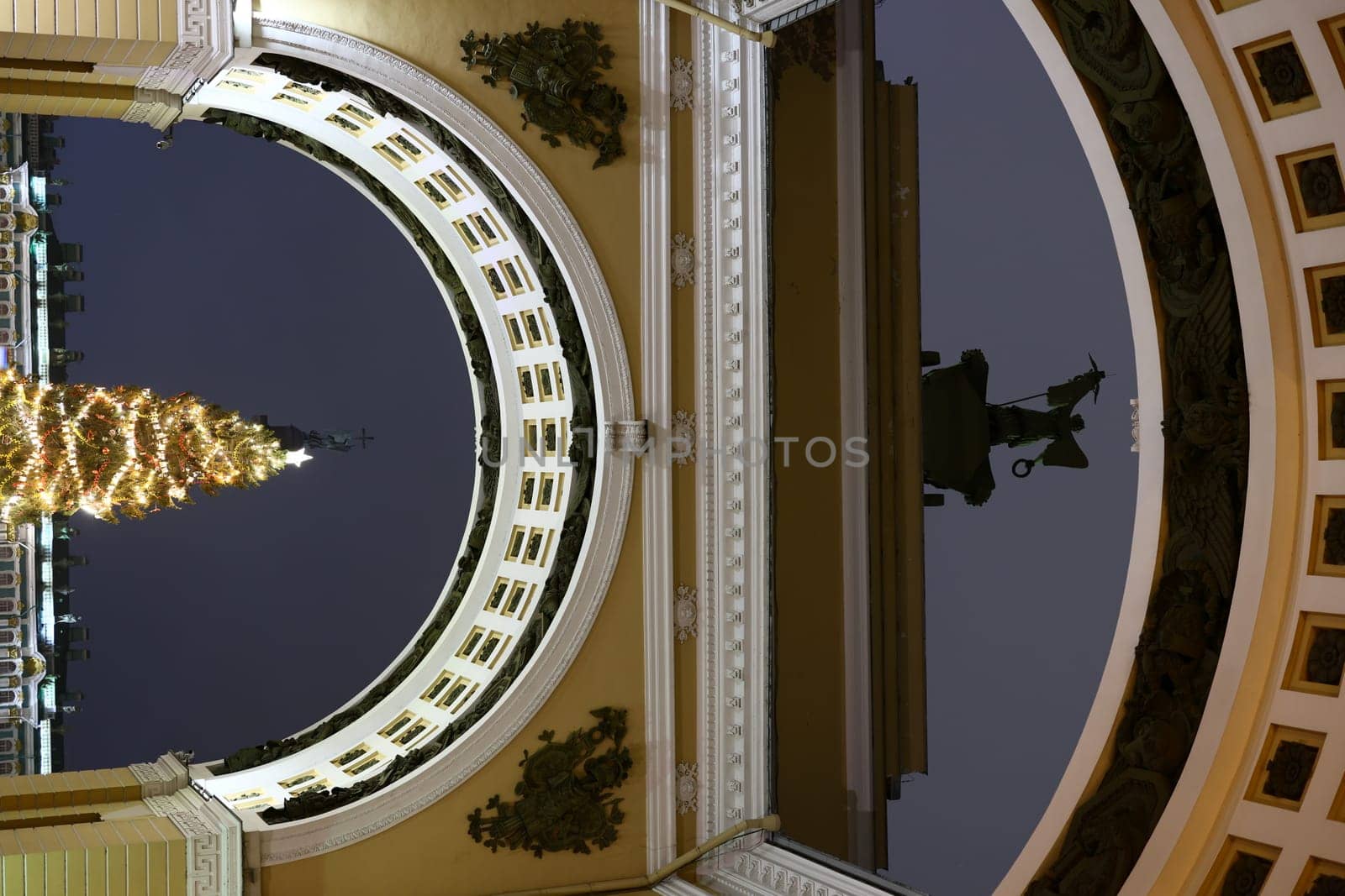 A breathtaking and stunning nighttime view of an archway adorned with a beautiful Christmas tree and its reflections