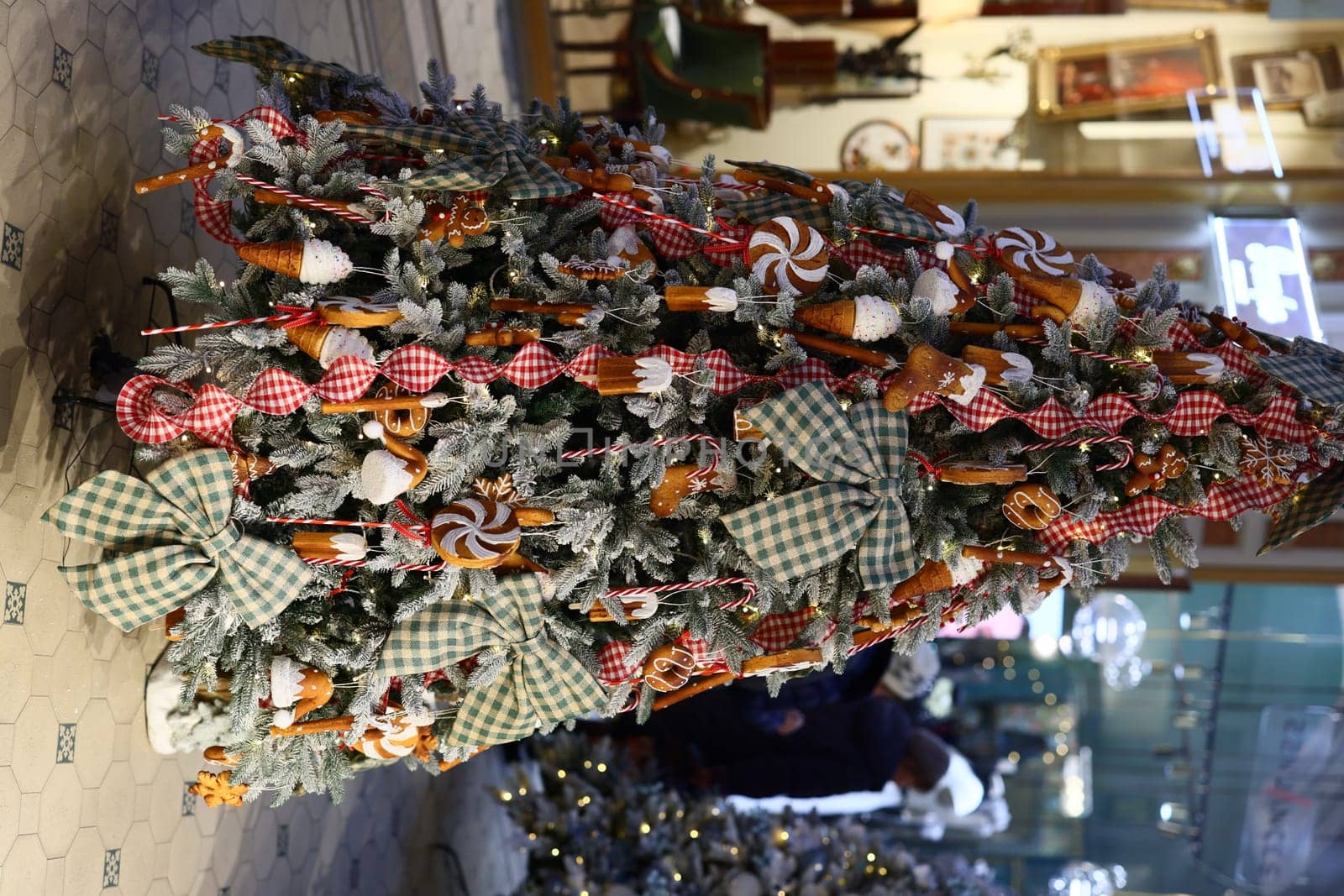 A beautiful and vibrant Christmas tree is adorned with colorful, candyinspired decorations and festive ribbons