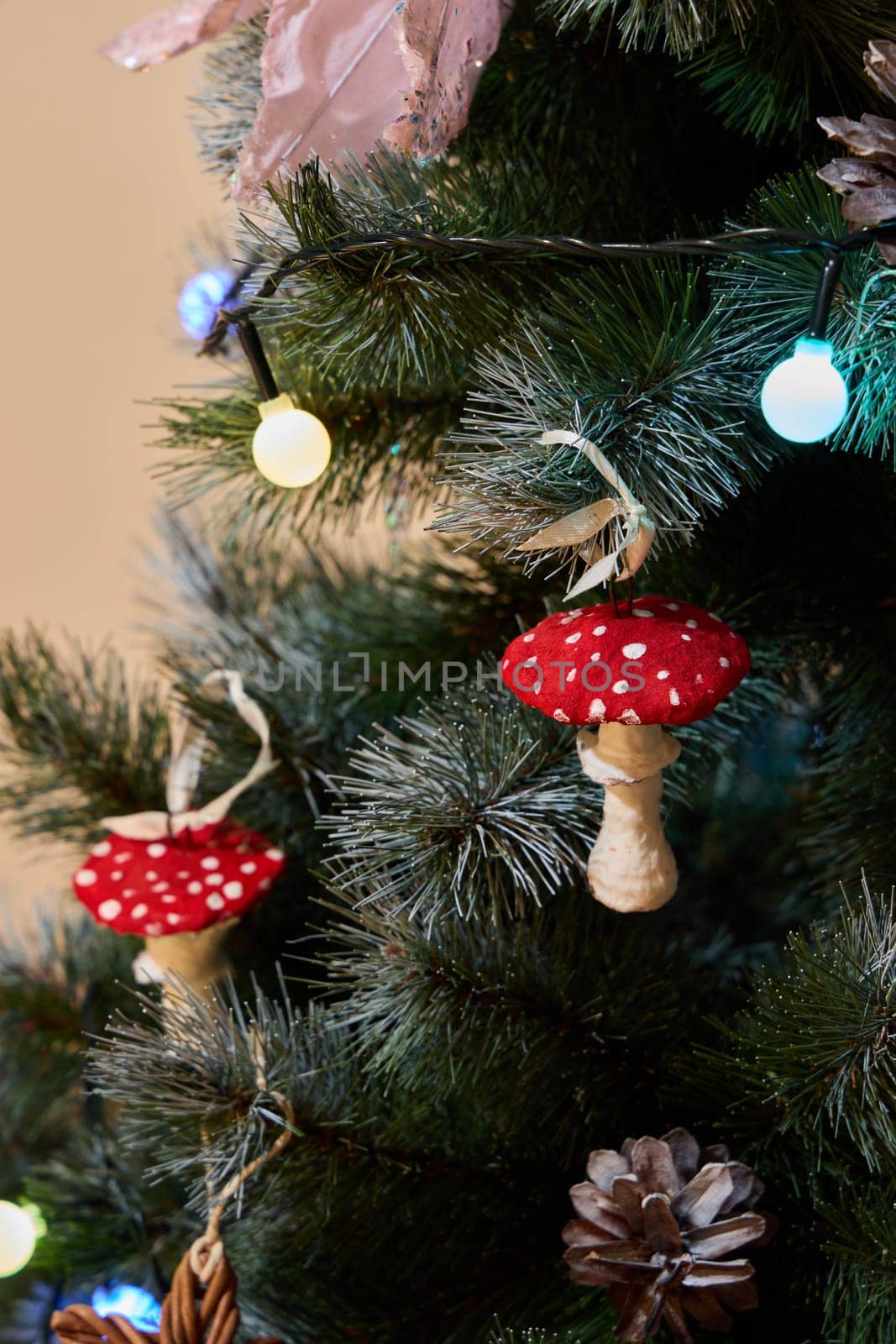 A festive Christmas tree is adorned with colorful red mushroom ornaments and surrounded by twinkling lights