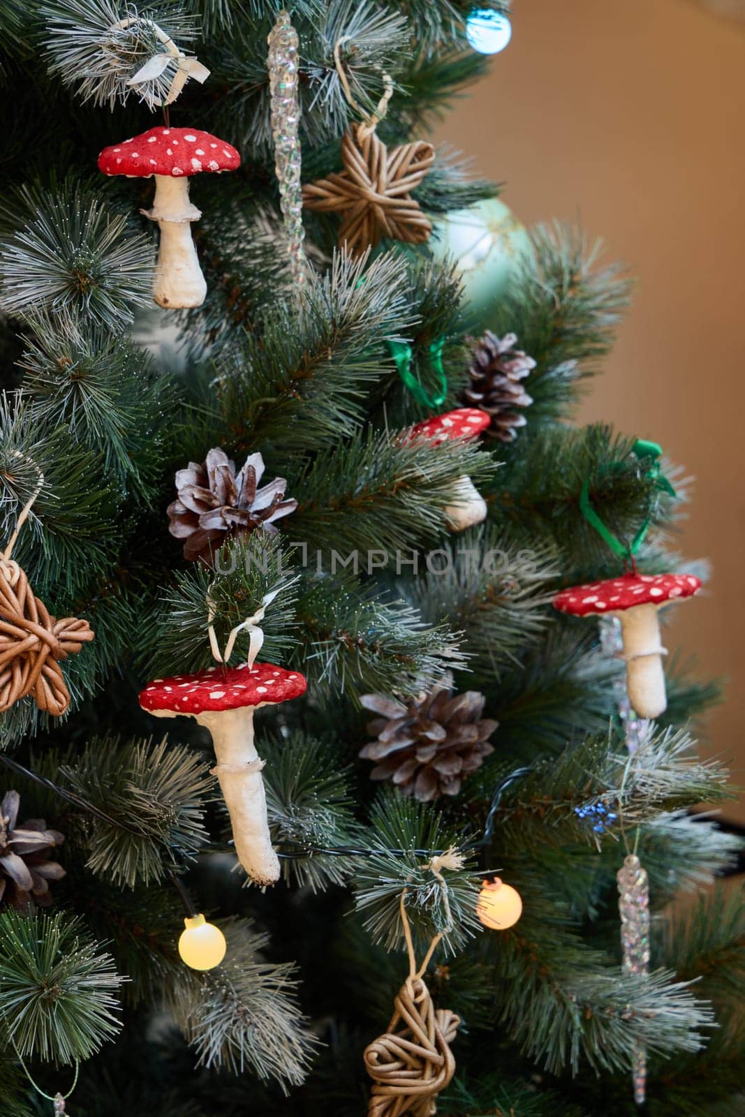 A festive Christmas tree is adorned with mushroom ornaments, pinecones, and rustic touches, bringing joy
