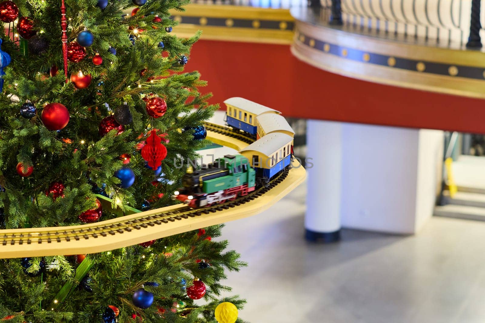 A cheerful train set thoughtfully adorning a beautifully designed Christmas tree with festive decorations