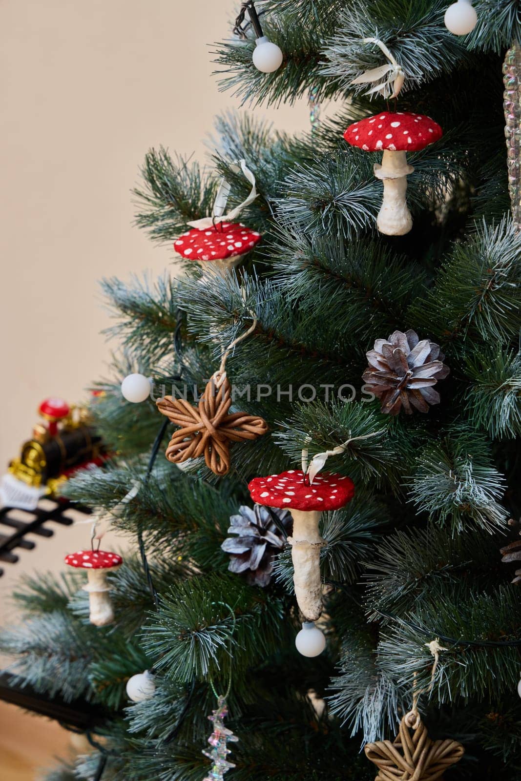 A decorated Christmas tree features charming mushroom ornaments and lovely pinecones, creating a festive vibe