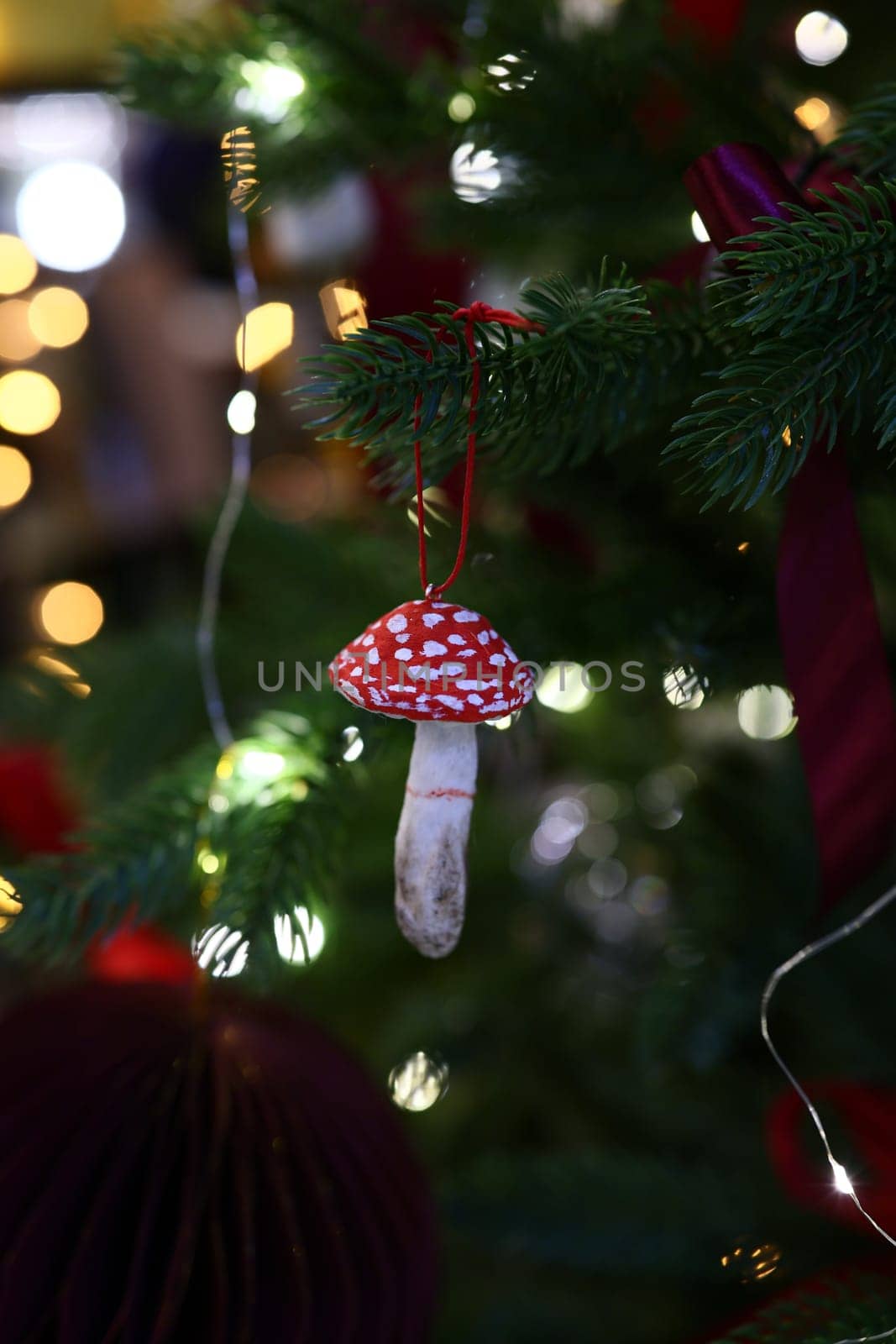 A vibrant red mushroom ornament adds a charming festive touch to your Christmas tree this holiday season