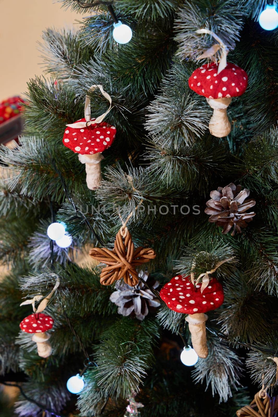 A beautifully festive Christmas tree is adorned with whimsical red mushroom ornaments along with lovely pine cones