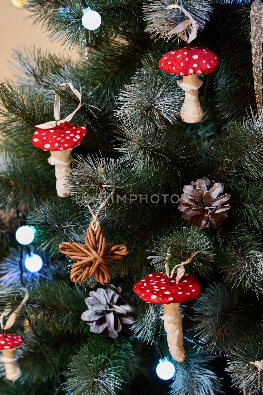 The festive Christmas tree is beautifully adorned with unique red mushroom ornaments and decorative pine cones