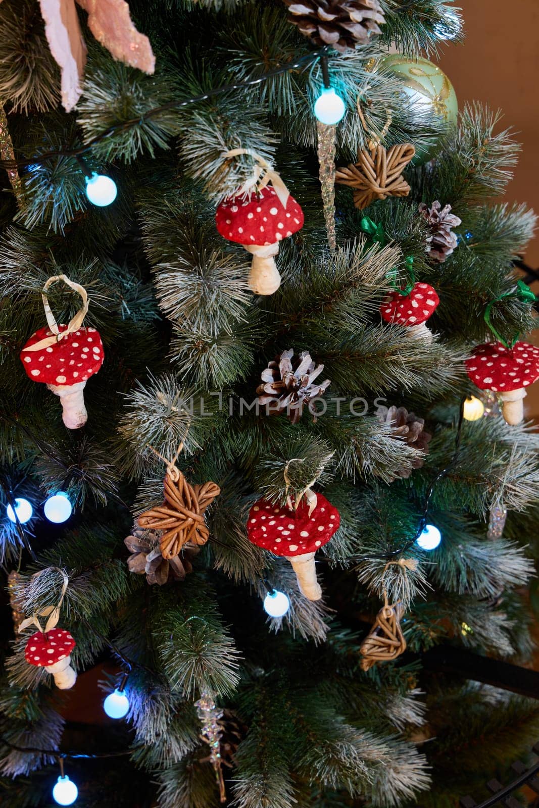 A beautifully decorated Christmas tree featuring charming red mushroom ornaments and twinkling lights.