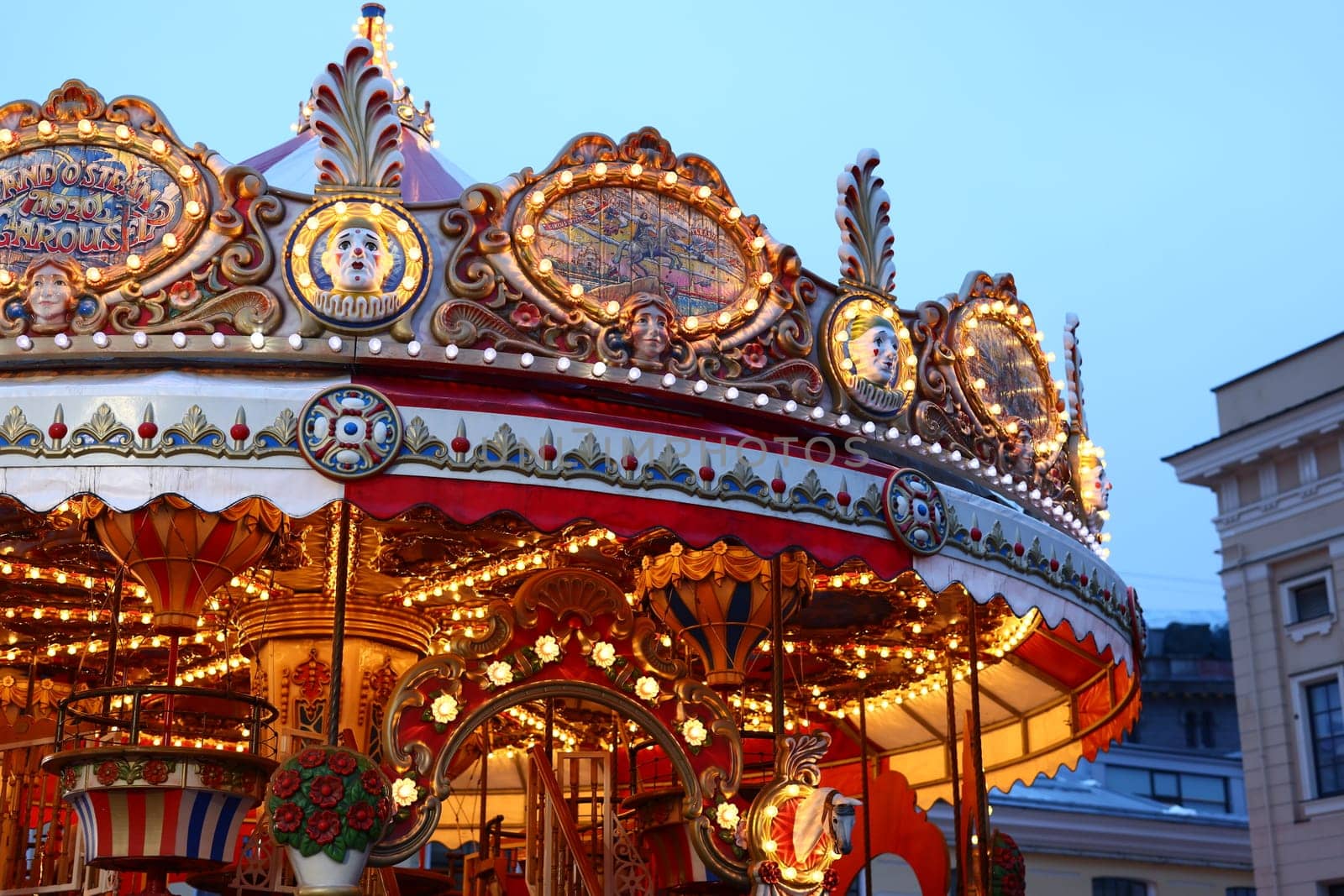 A beautifully lit carousel during dusk, showcasing its vibrant colors and intricate designs for all to enjoy