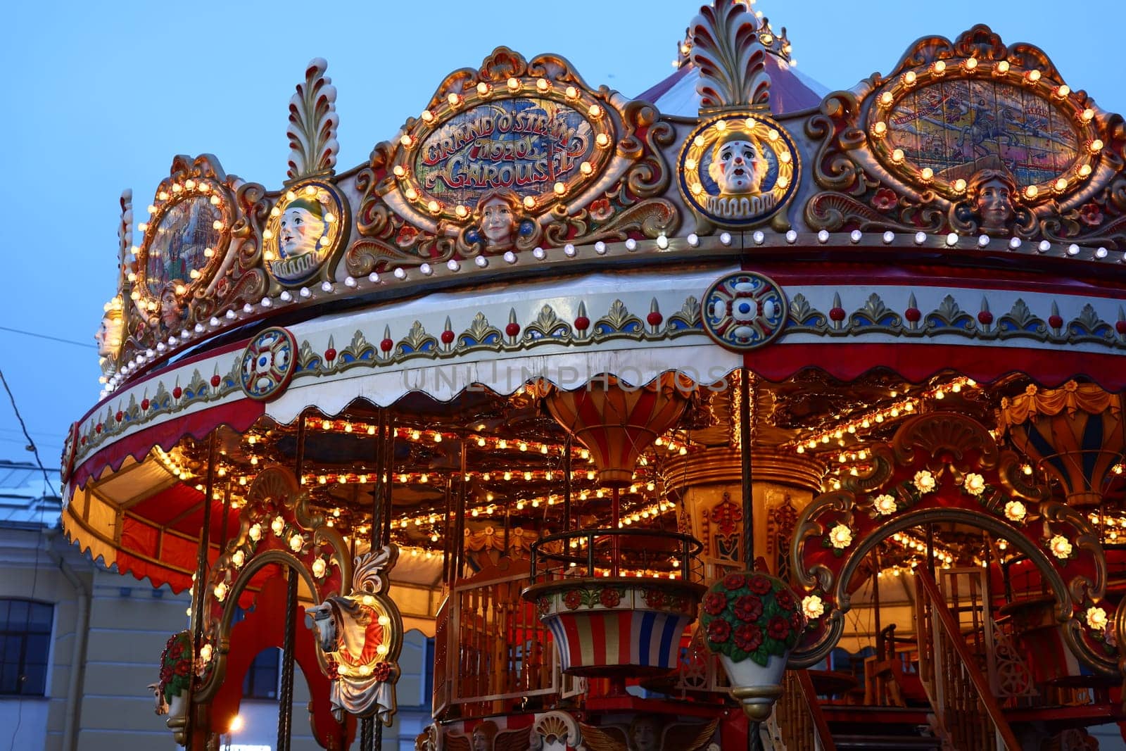 A beautifully lit carousel adorned with ornate decorations, creating a truly enchanting magical evening atmosphere