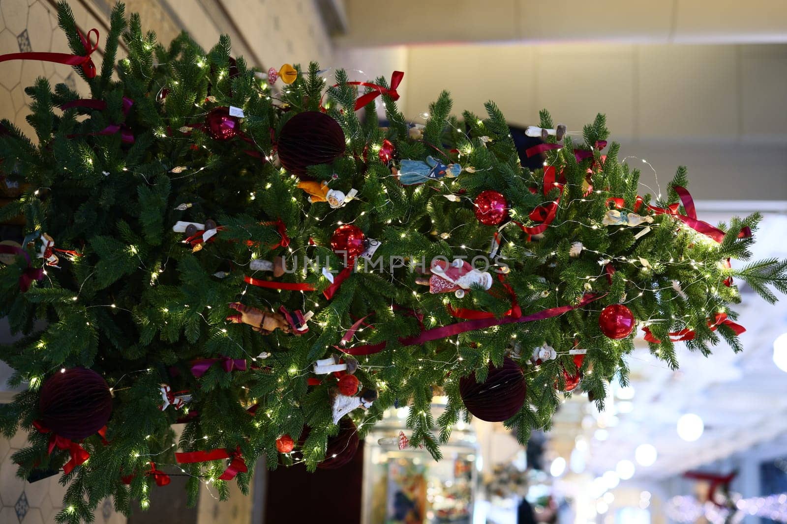 A beautifully adorned Christmas tree featuring vibrant lights and colorful ornaments set in a sophisticated space