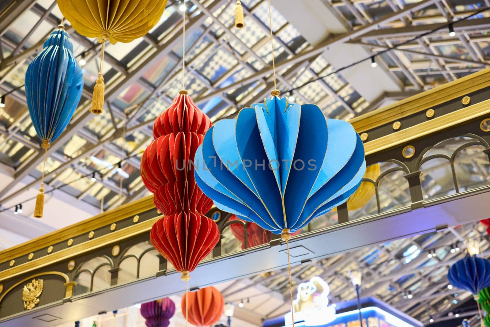 The vibrant design of hanging lanterns in a contemporary shopping mall atrium creates a lively atmosphere