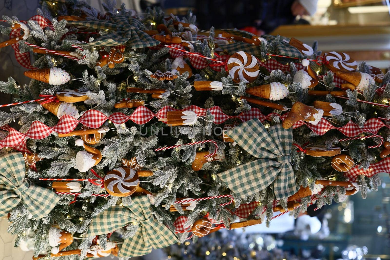 A beautifully decorated Christmas tree adorned with colorful candy, shiny bows, and delightful holiday treats