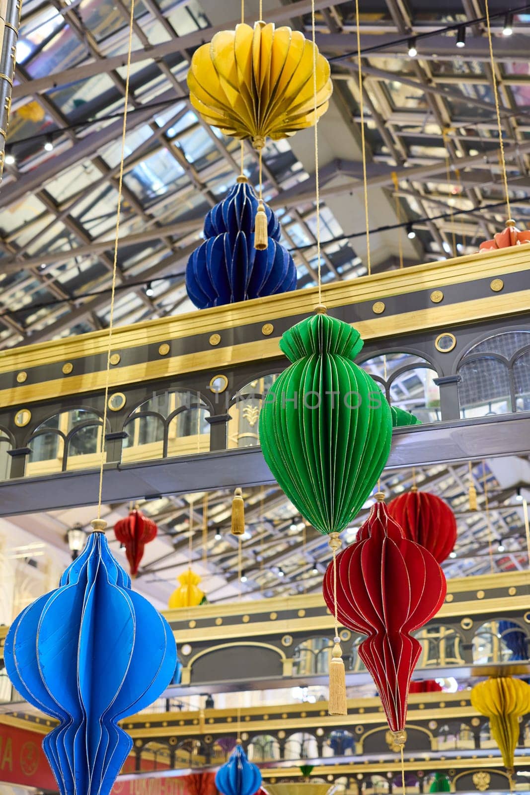 Vibrant and decorative lanterns are beautifully suspended in a meticulously designed indoor space, enhancing its charm