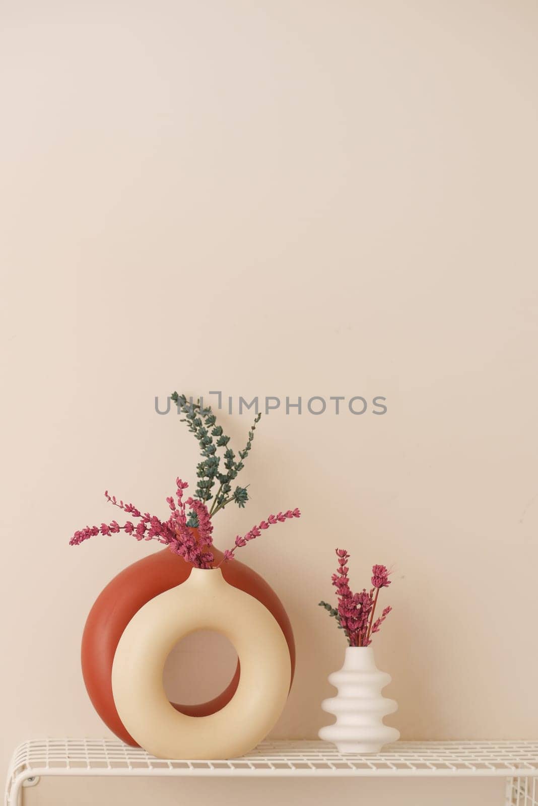 Stylish and elegant vases filled with vibrant, colorful flowers against a neutral background