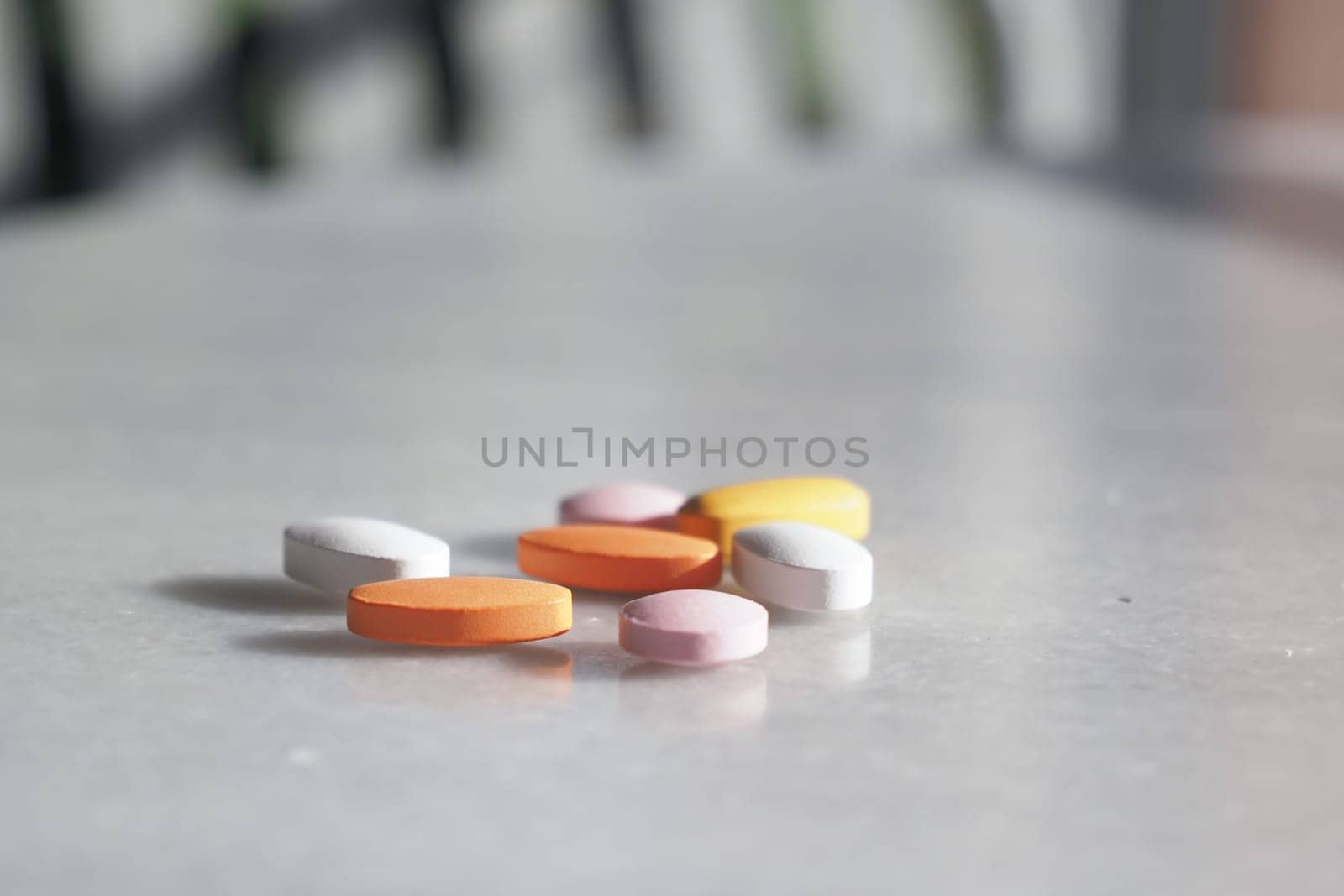 A colorful assortment of essential vitamins and medications spilled from a bottle onto the surface
