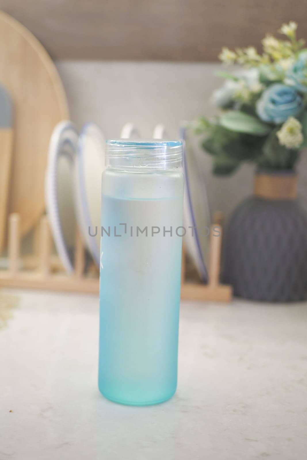 Blue Gradient Bottle on Kitchen Counter With Dishes ,