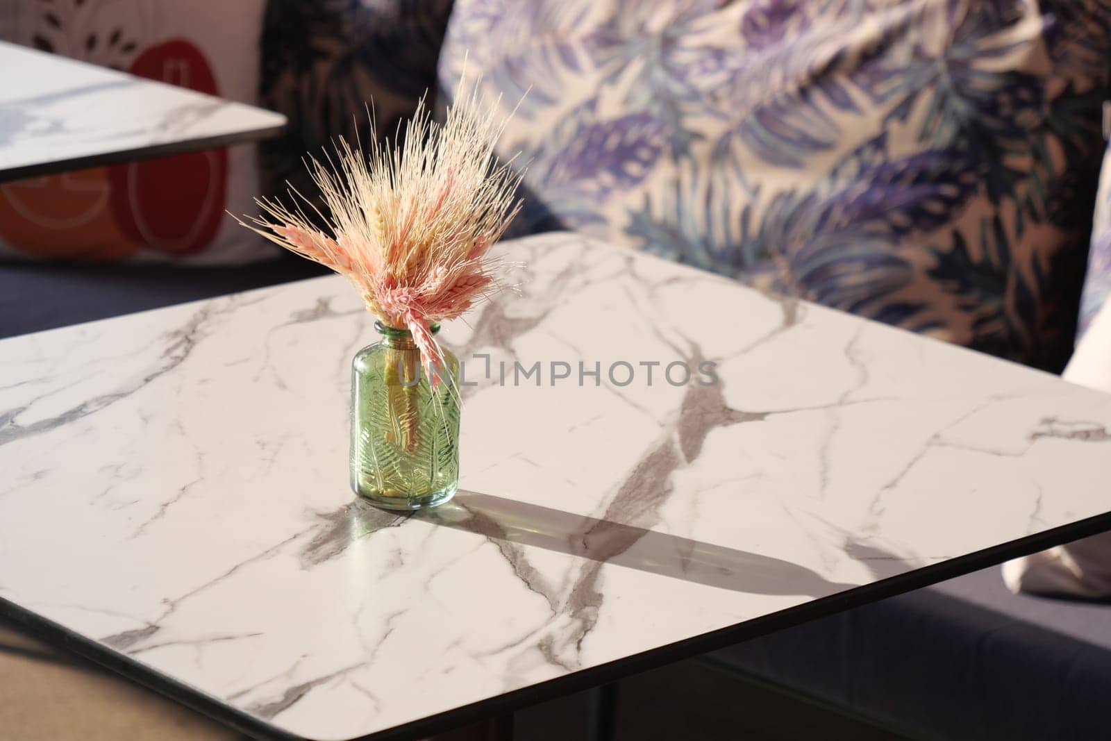 This is a beautiful modern table setting that showcases a lovely vase filled with dried flowers