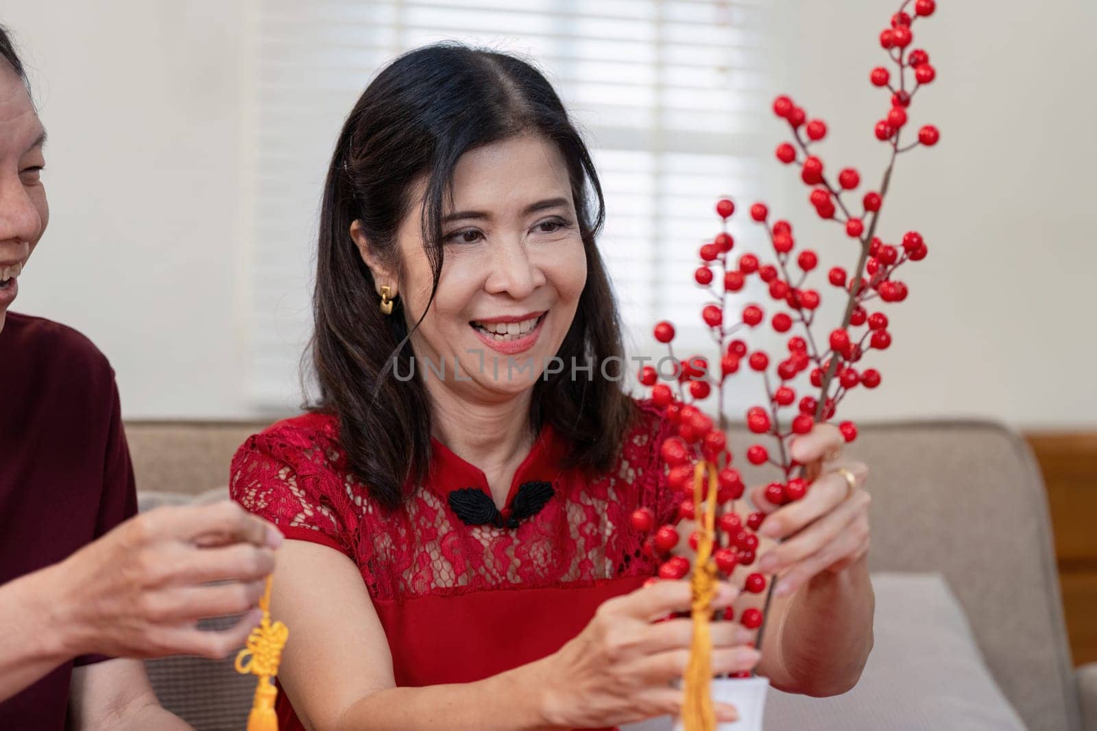An elderly couple joyfully prepares decorations for the Chinese New Year at home embracing tradition and togetherness.