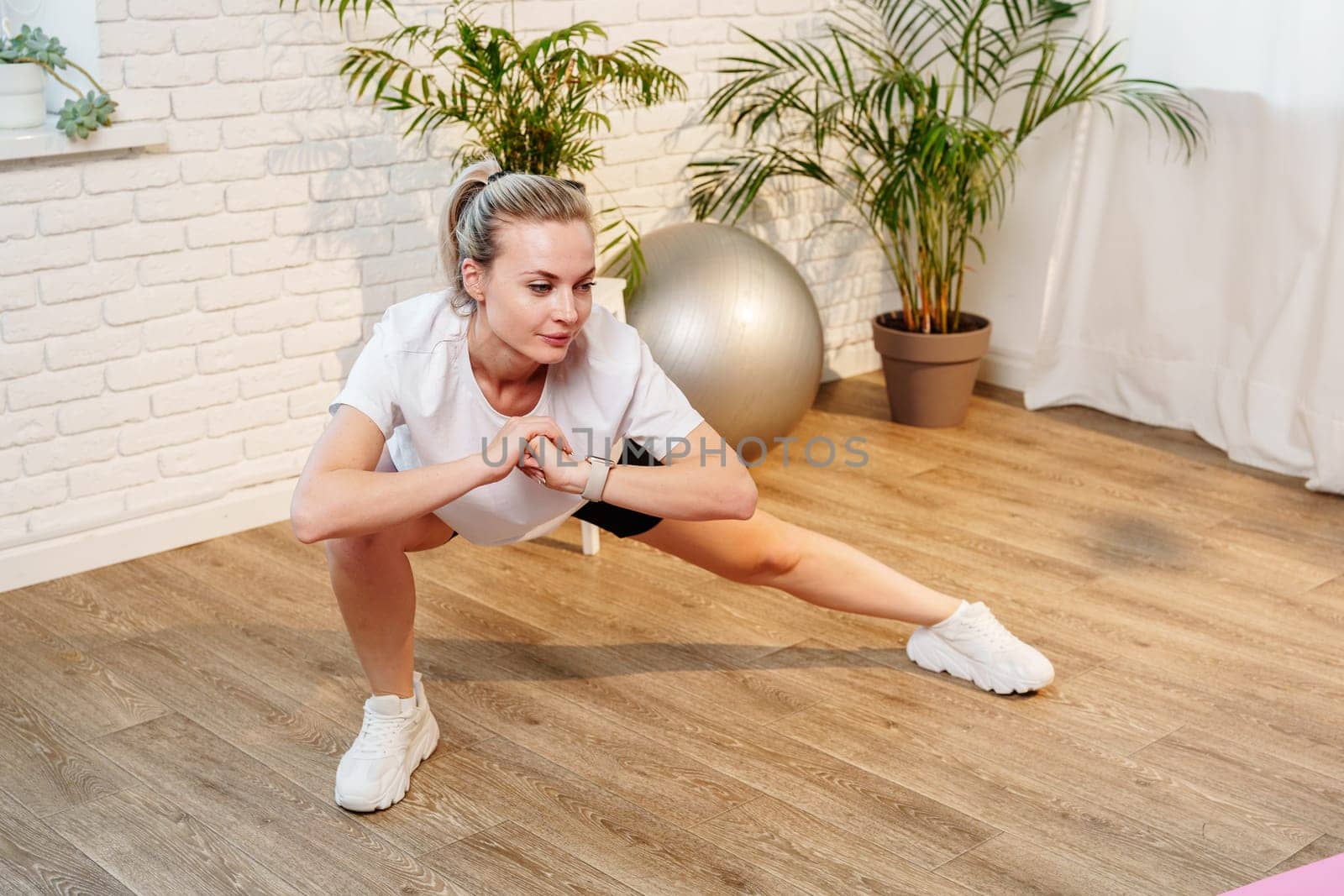 Woman performing a stretching exercise in a bright indoor fitness space