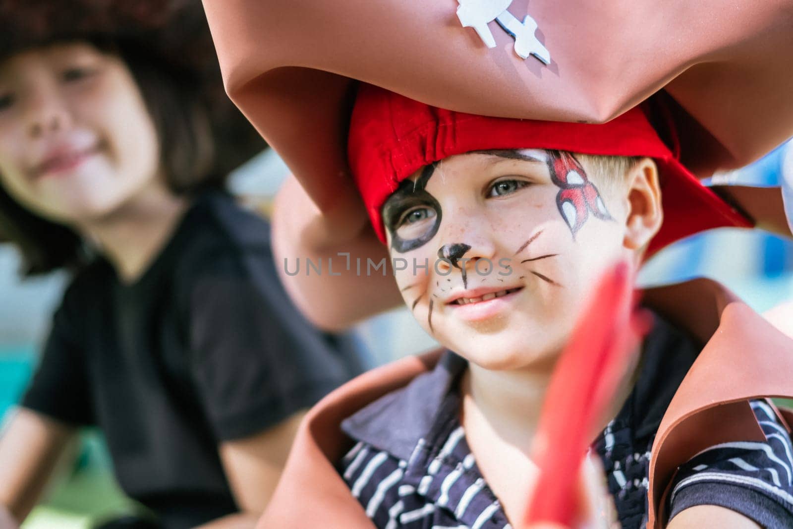 Boy Cat Pirate costume. Halloween party in kindergarten. Aqua makeup painted kids face. Bright festive.