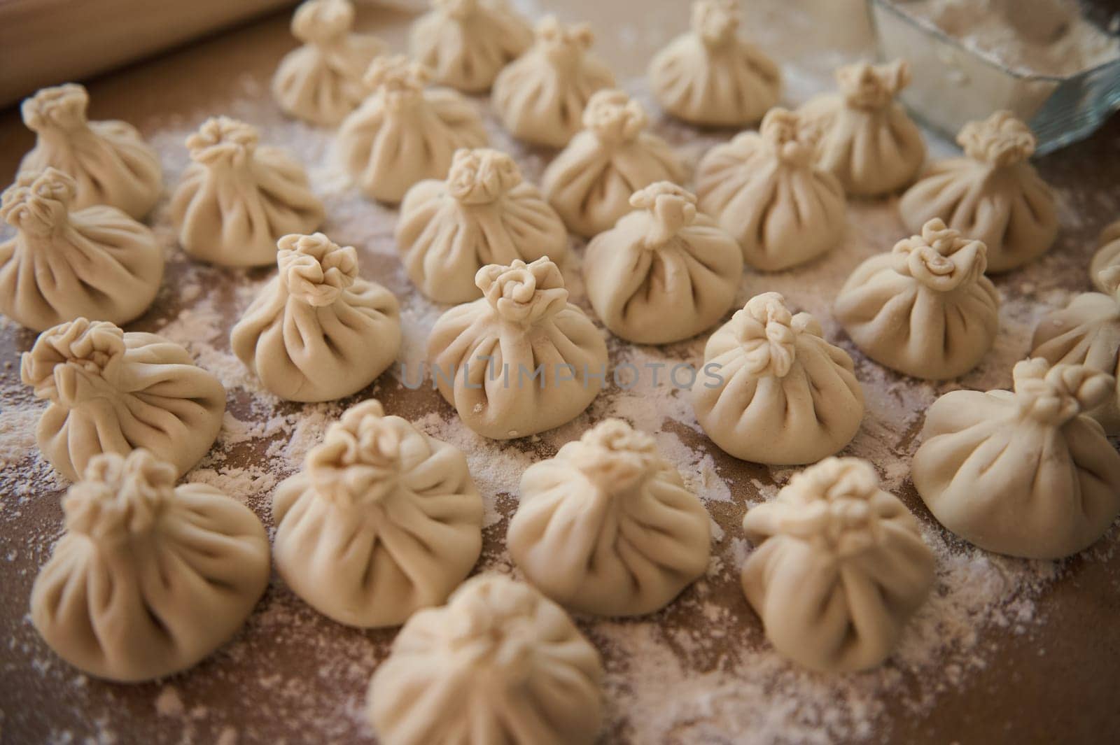 Homemade Georgian dumplings, also known as Xinkali, arranged on a flour-dusted surface, highlighting their traditional culinary artistry.