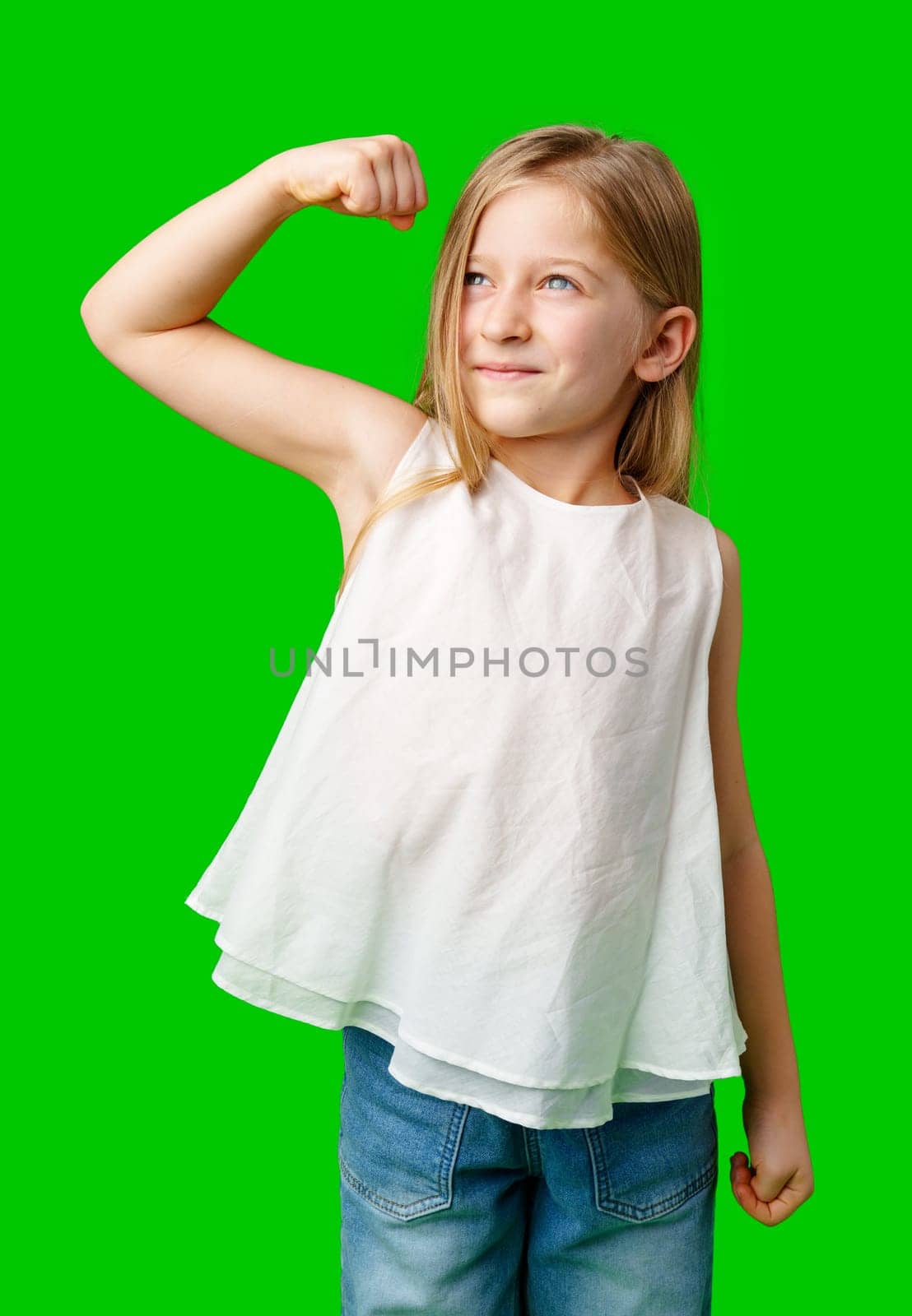 A confident girl flexing her muscles in a bright green background