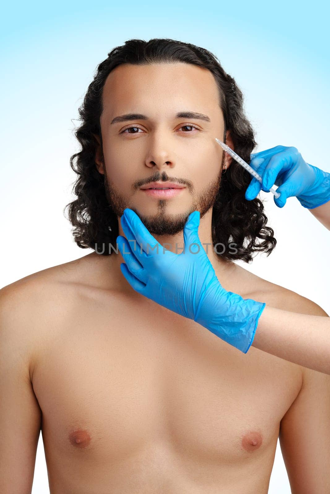 Man receiving cosmetic treatment with a syringe, showcasing a beauty procedure in a clinical setting
