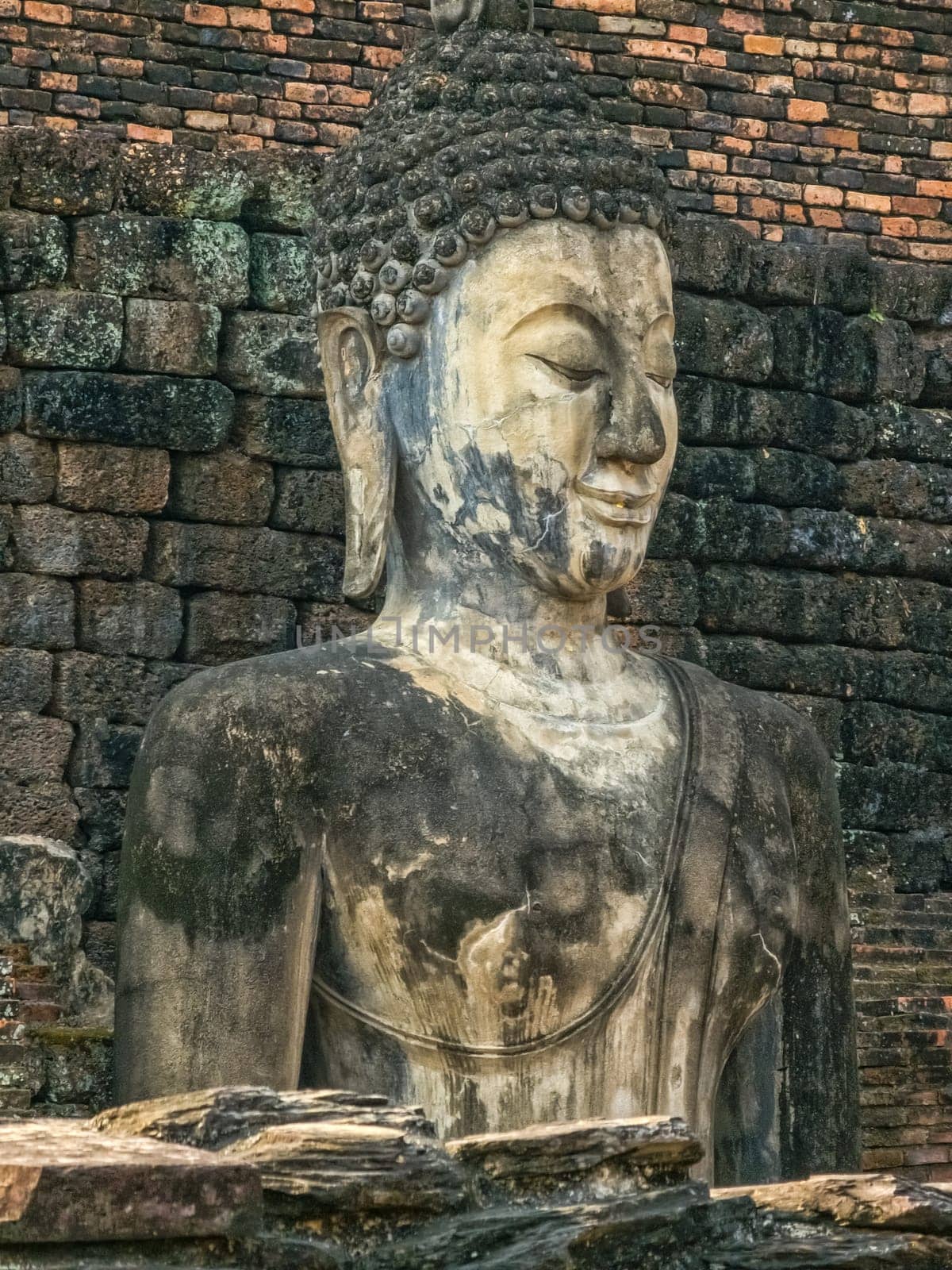 Buddha statue at Wat Mahathat Maha That temple by day, Sukhothai, Thailand