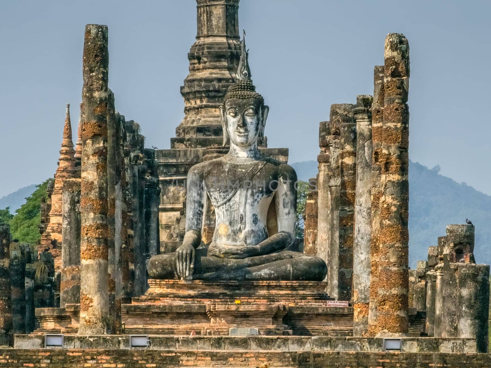 Buddha statue at Wat Mahathat Maha That temple by day, Sukhothai, Thailand