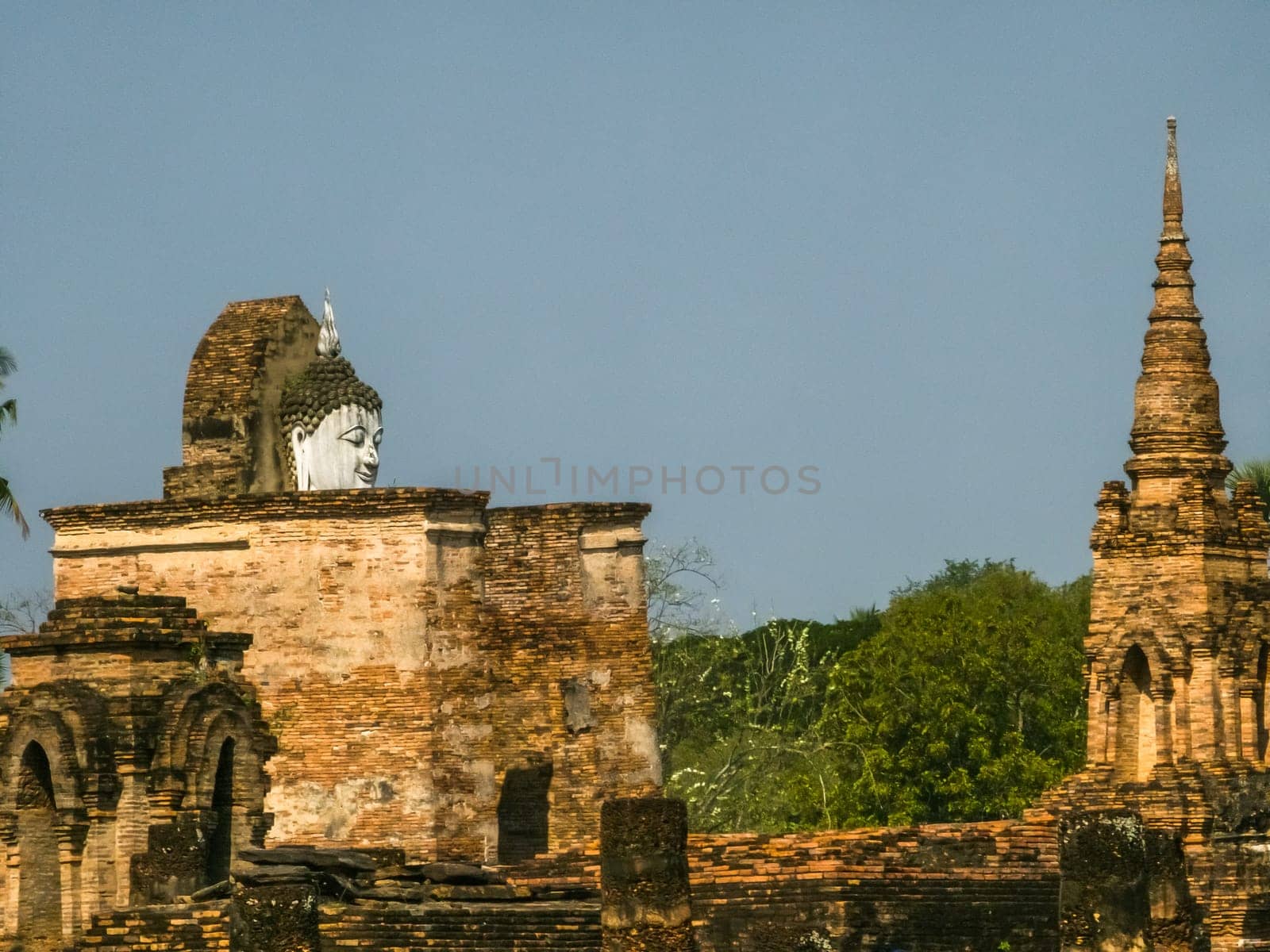 Buddha statue at Wat Mahathat Maha That temple by day, Sukhothai, Thailand