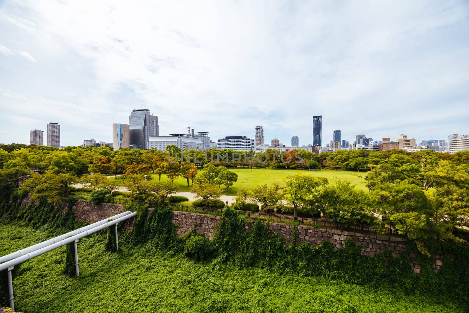 OSAKA, JAPAN - SEPTEMBER 25 2024: The iconic Osaka Castle and surrounding moat and gardens on a warm clear autumn day in Osaka, Japan on September 25th 2024