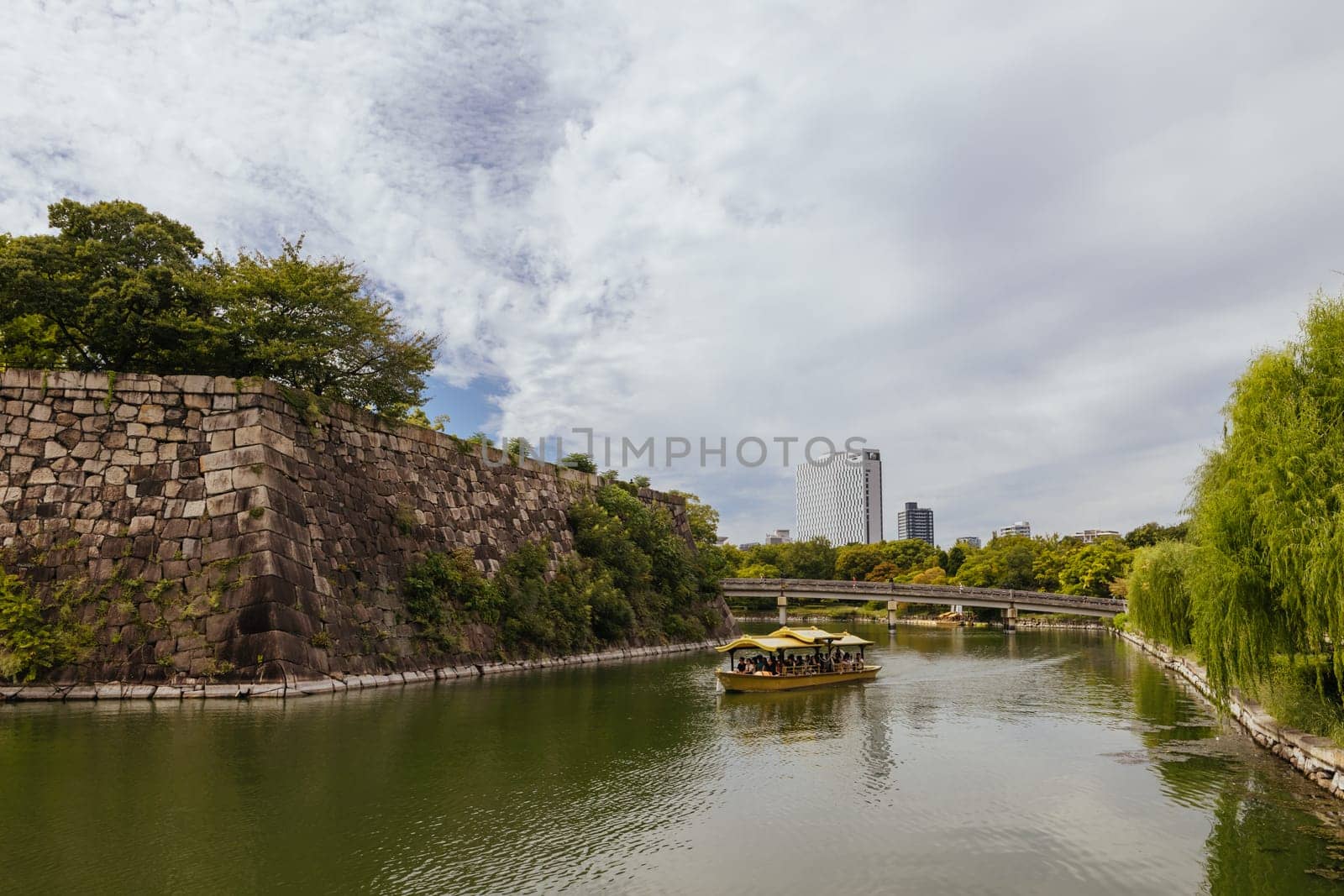 OSAKA, JAPAN - SEPTEMBER 25 2024: The iconic Osaka Castle and surrounding moat and gardens on a warm clear autumn day in Osaka, Japan on September 25th 2024