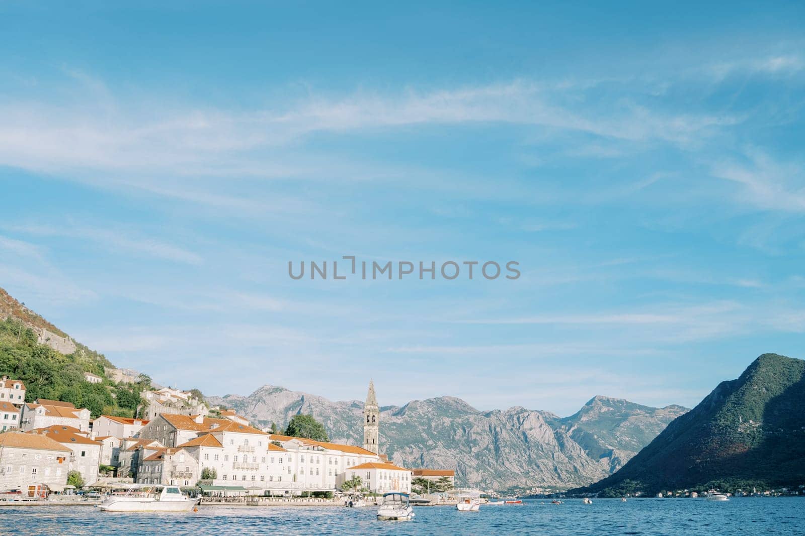 Old stone houses with a bell tower of the church of the town of Perast on the seashore. Montenegro. High quality photo