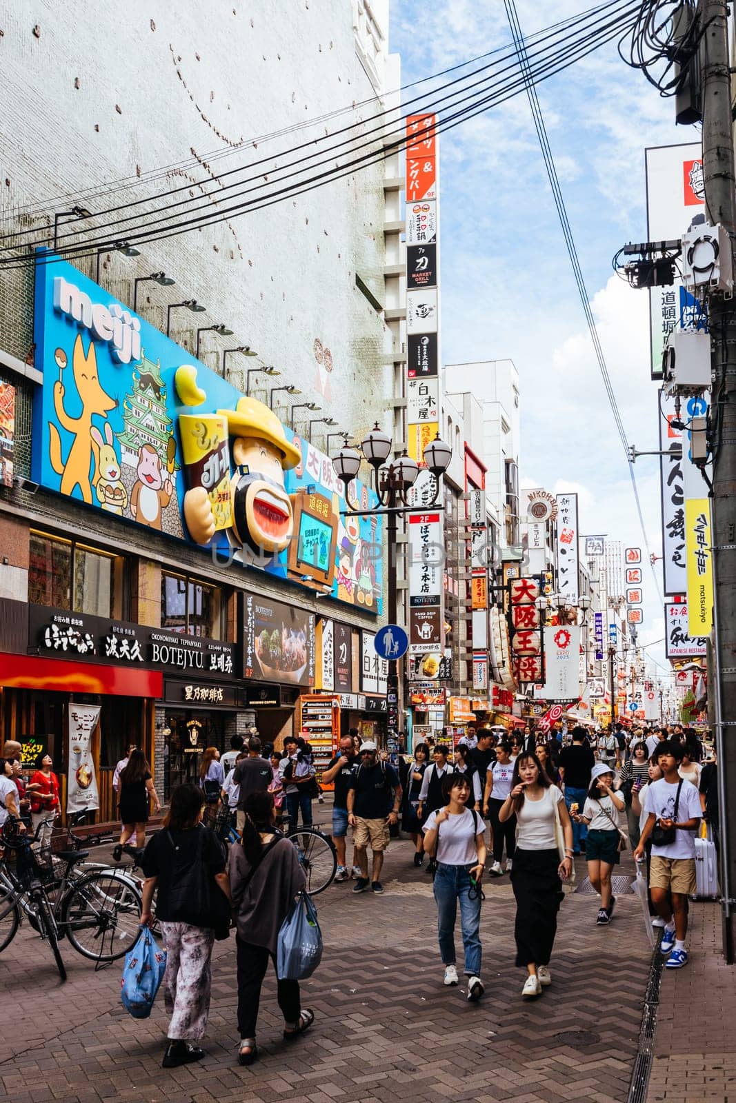 OSAKA, JAPAN - SEPTEMBER 24 2024: Osaka's famous Dotonbori area with many restaurants and iconic food signage at dusk in Osaka, Japan