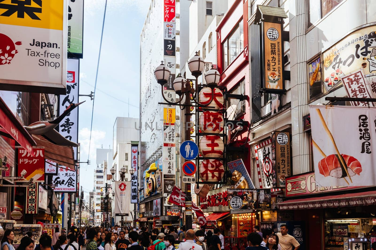 OSAKA, JAPAN - SEPTEMBER 24 2024: Osaka's famous Dotonbori area with many restaurants and iconic food signage at dusk in Osaka, Japan