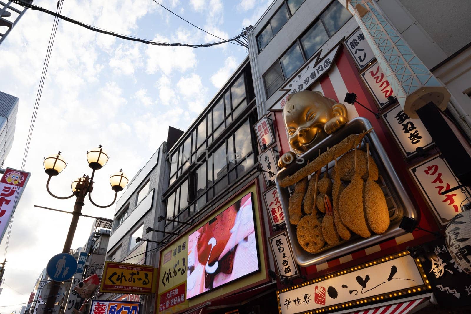 OSAKA, JAPAN - SEPTEMBER 24 2024: Osaka's famous Dotonbori area with many restaurants and iconic food signage at dusk in Osaka, Japan