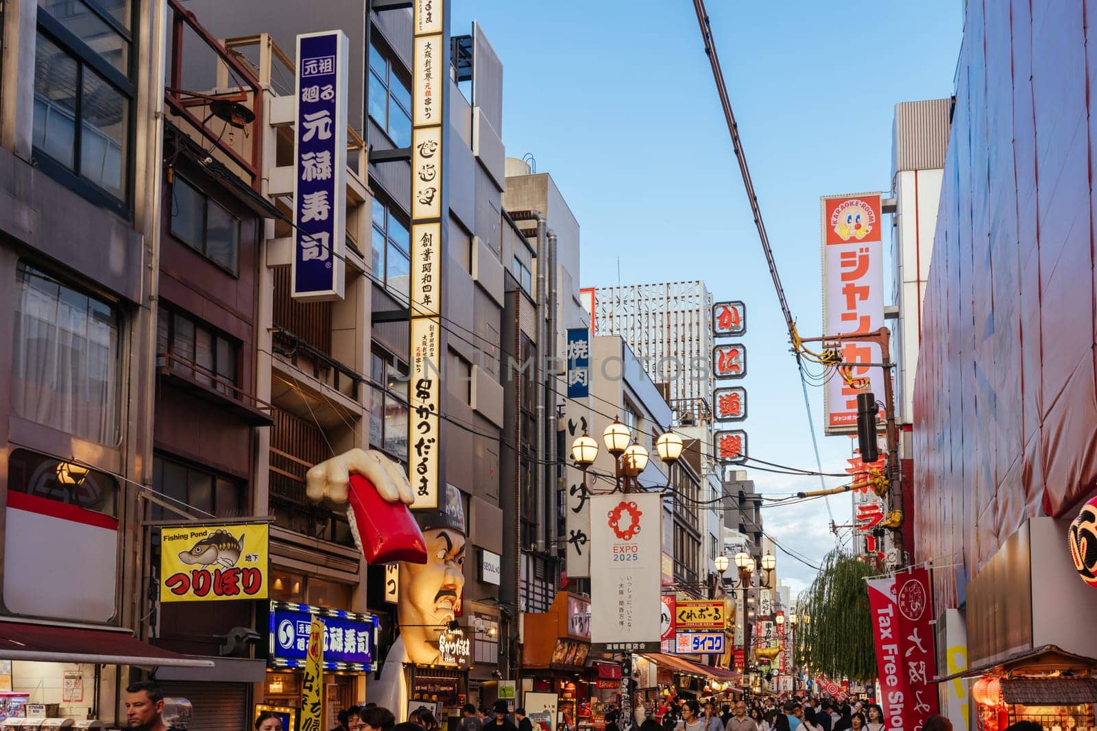 OSAKA, JAPAN - SEPTEMBER 24 2024: Osaka's famous Dotonbori area with many restaurants and iconic food signage at dusk in Osaka, Japan