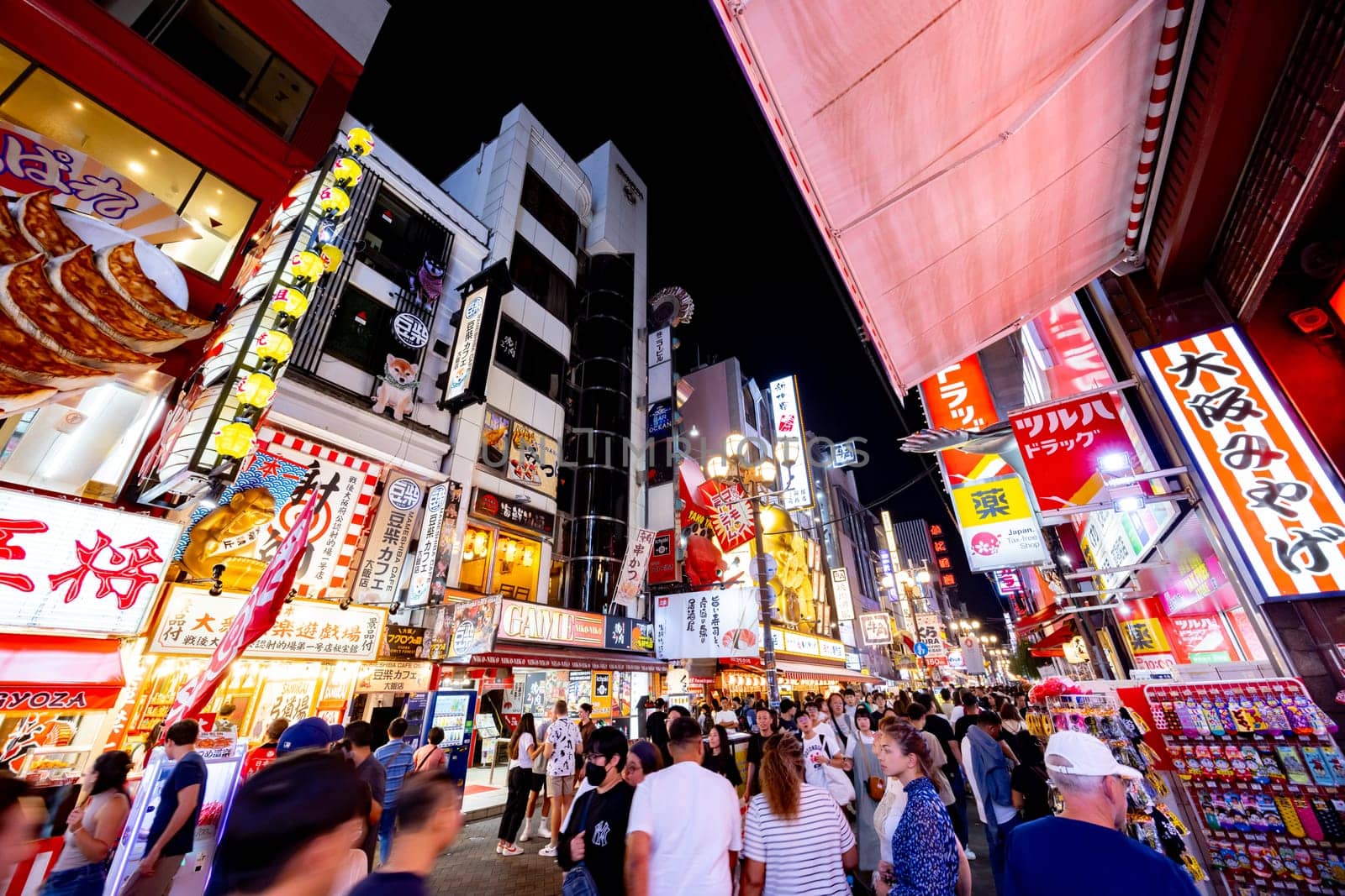 OSAKA, JAPAN - SEPTEMBER 25 2024: Osaka's famous Dotonbori area with many restaurants and iconic food signage at dusk in Osaka, Japan