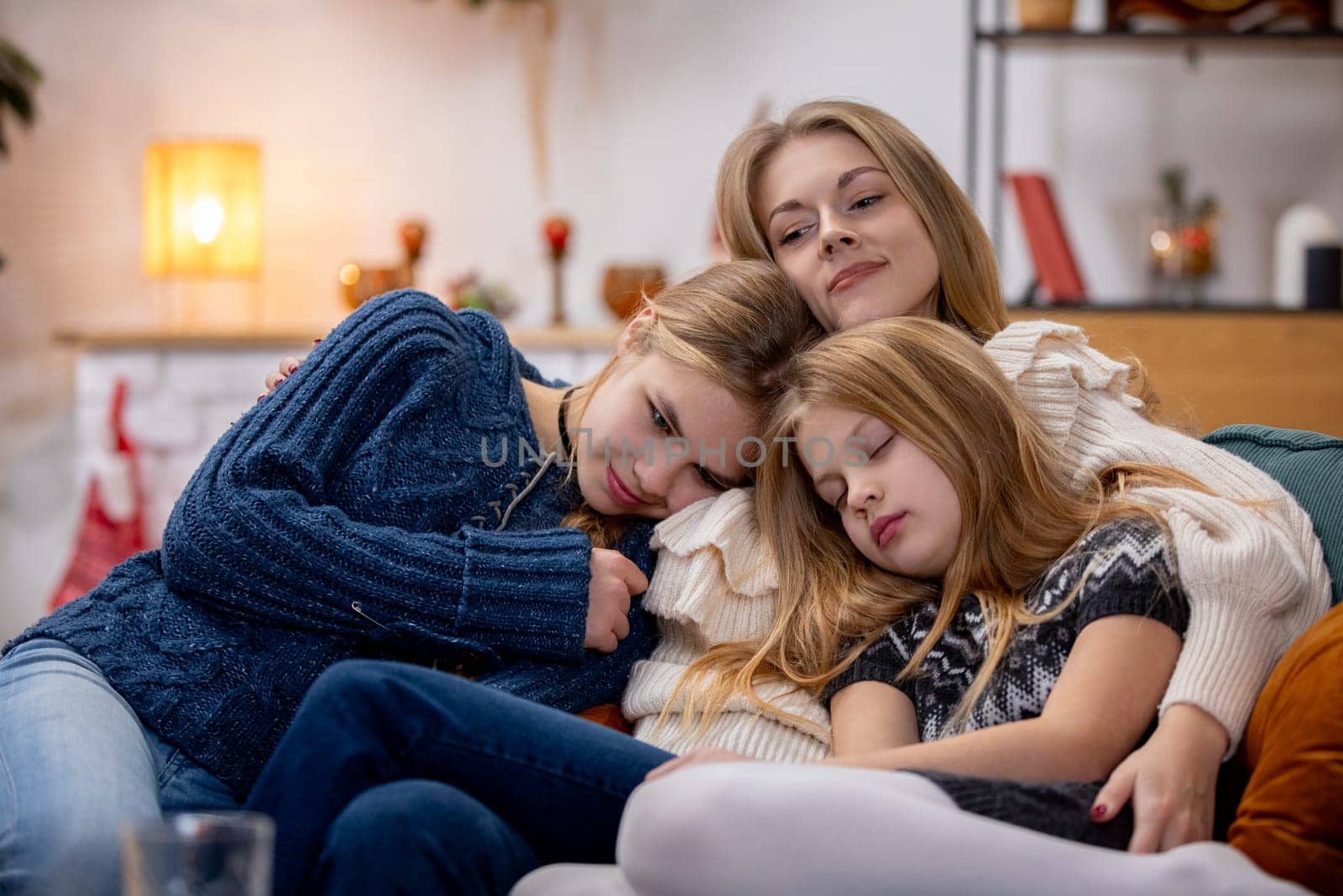 A loving mother and her two daughters share a cozy moment at home, showcasing their strong bond and warmth