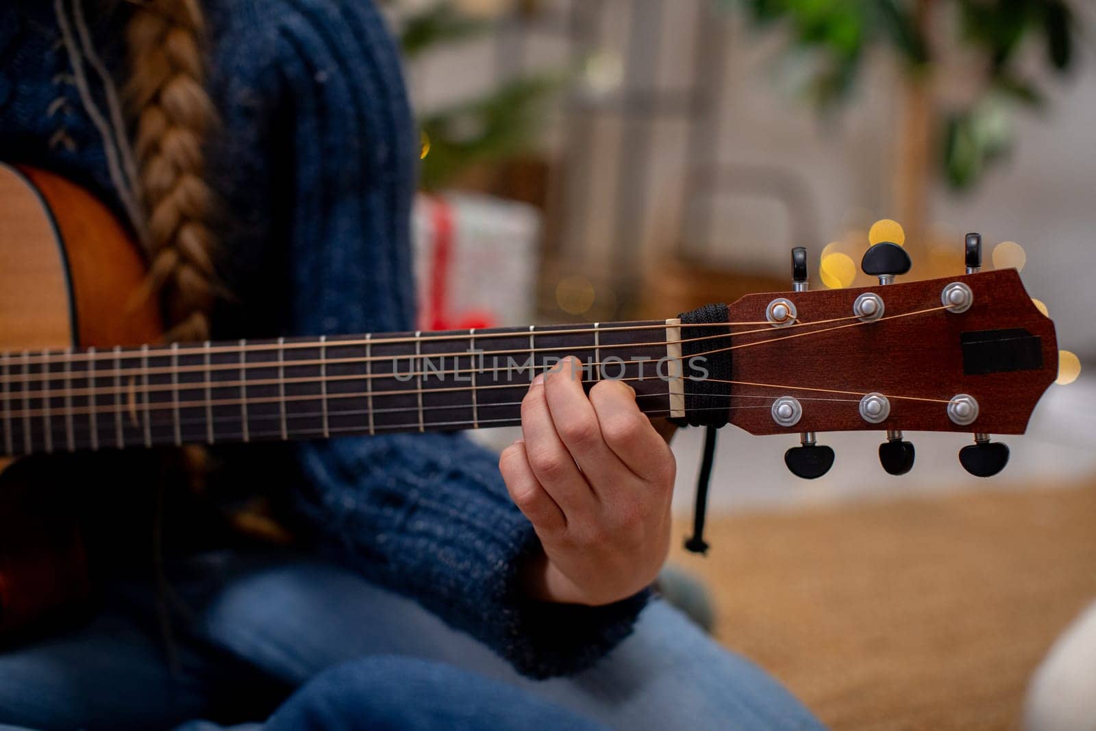 A skilled hand skillfully strumming the strings of an acoustic guitar, creating music in a warm, inviting atmosphere