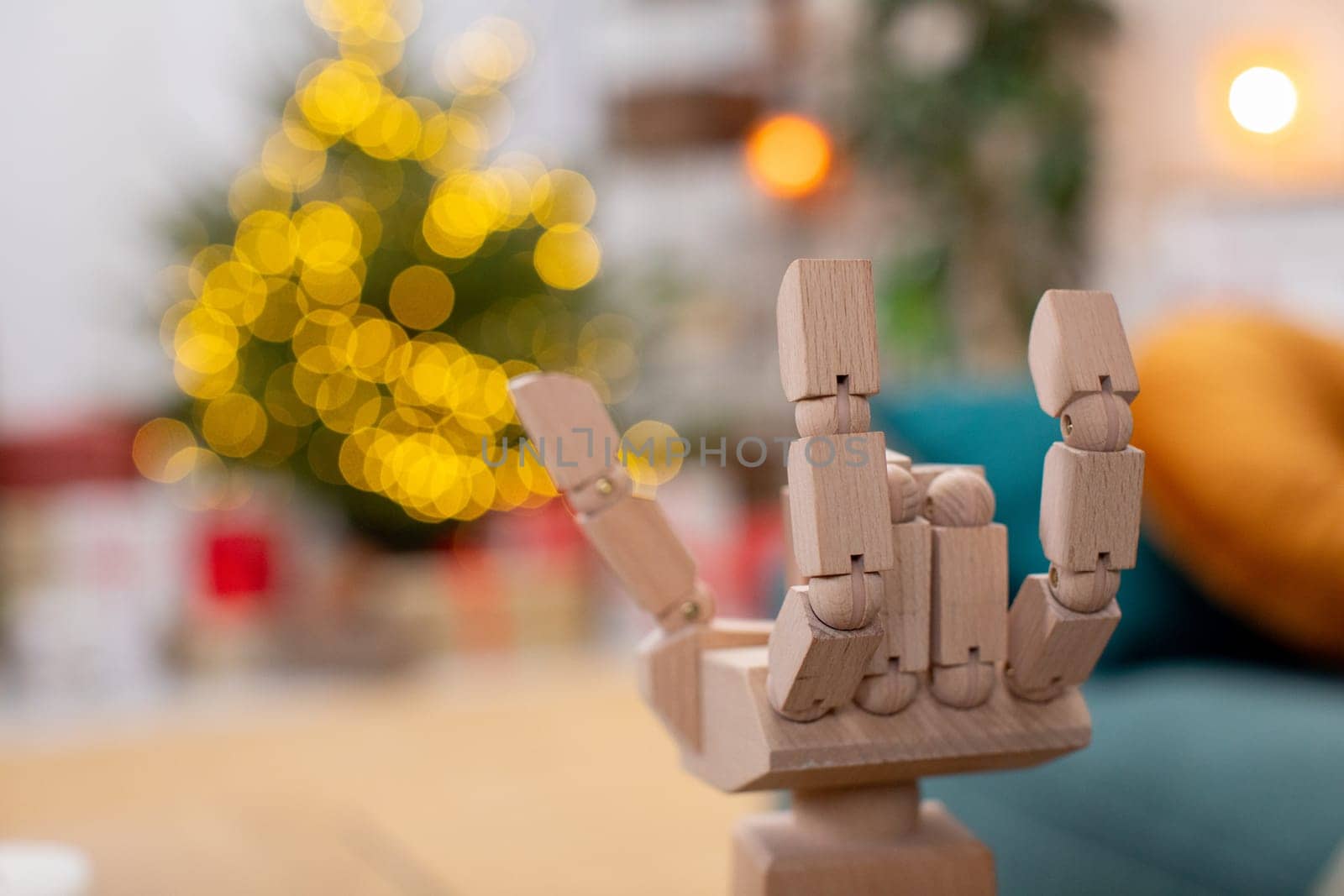 A wooden hand model artistically shows a rock music gesture, set against a vibrant festive background