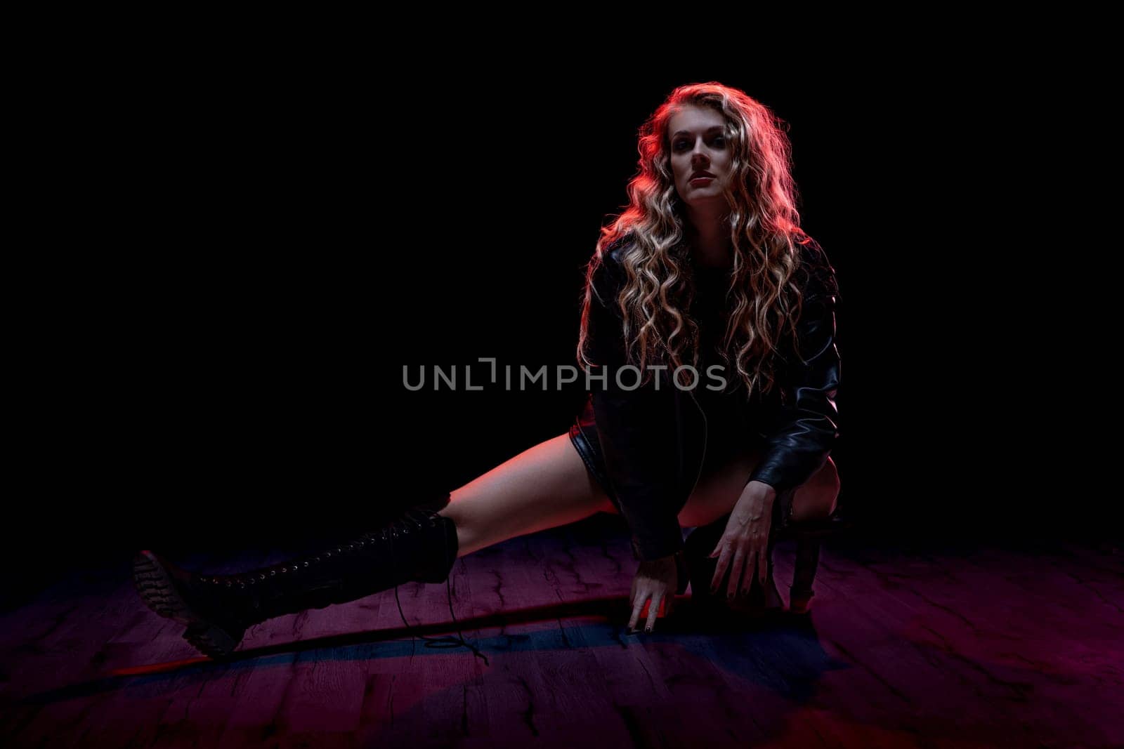 A stunning and striking portrait that beautifully showcases a woman posed dramatically against vibrant lighting