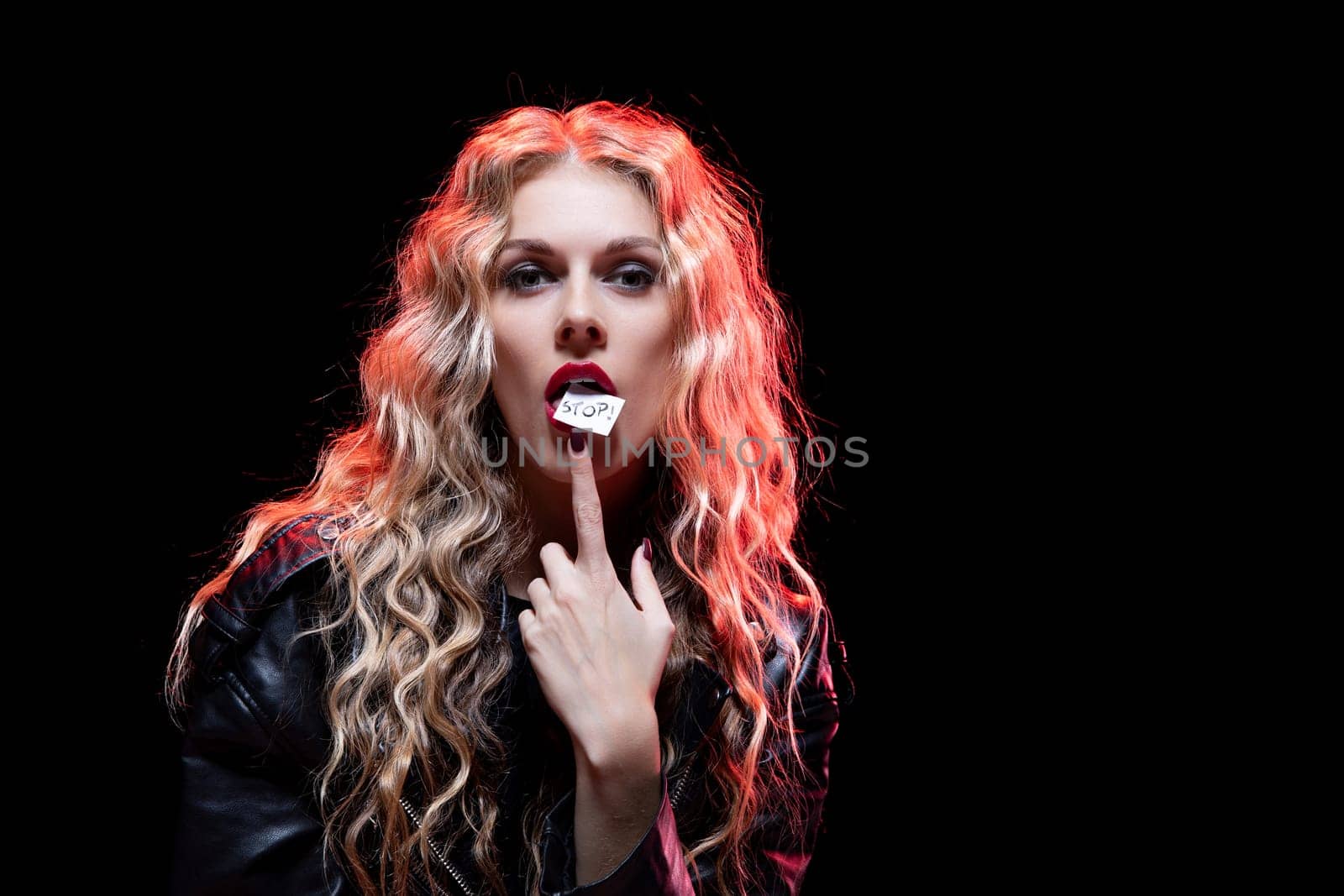 This captivating portrait features a model with curly hair, bold makeup, and an expressive pose, exuding an edgy vibe