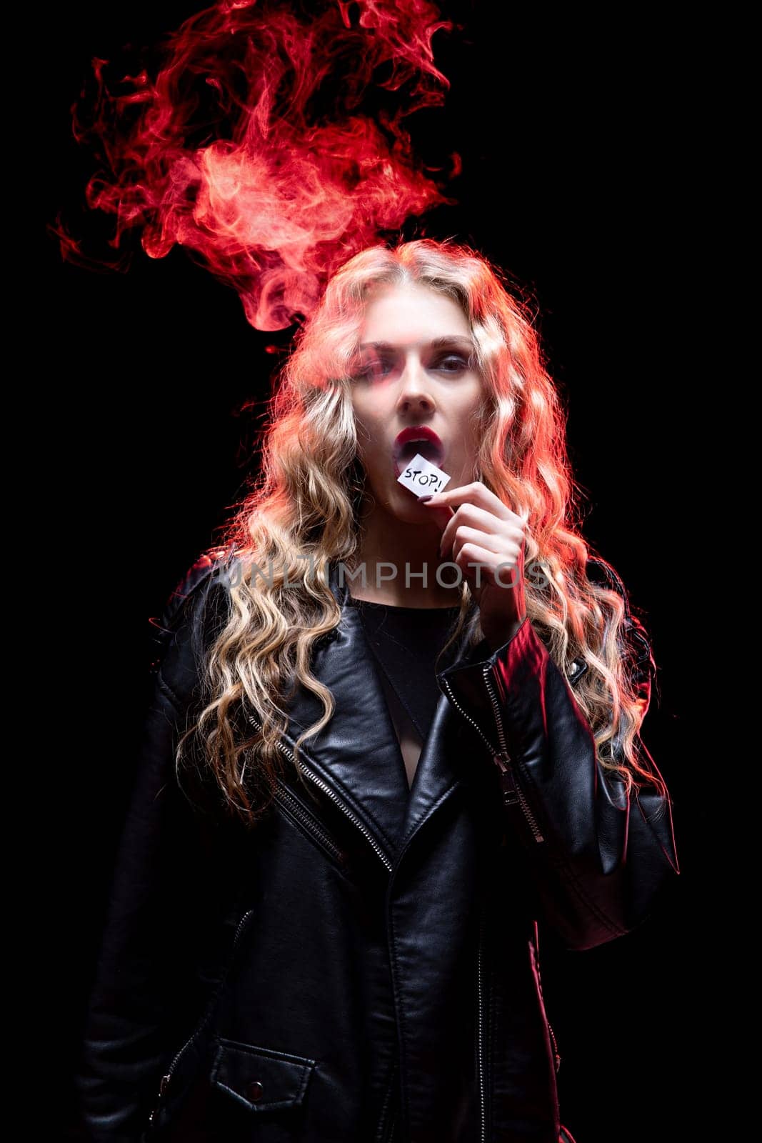 A striking woman with long flowing hair exhaling wisps of smoke while confidently wearing a stylish leather jacket
