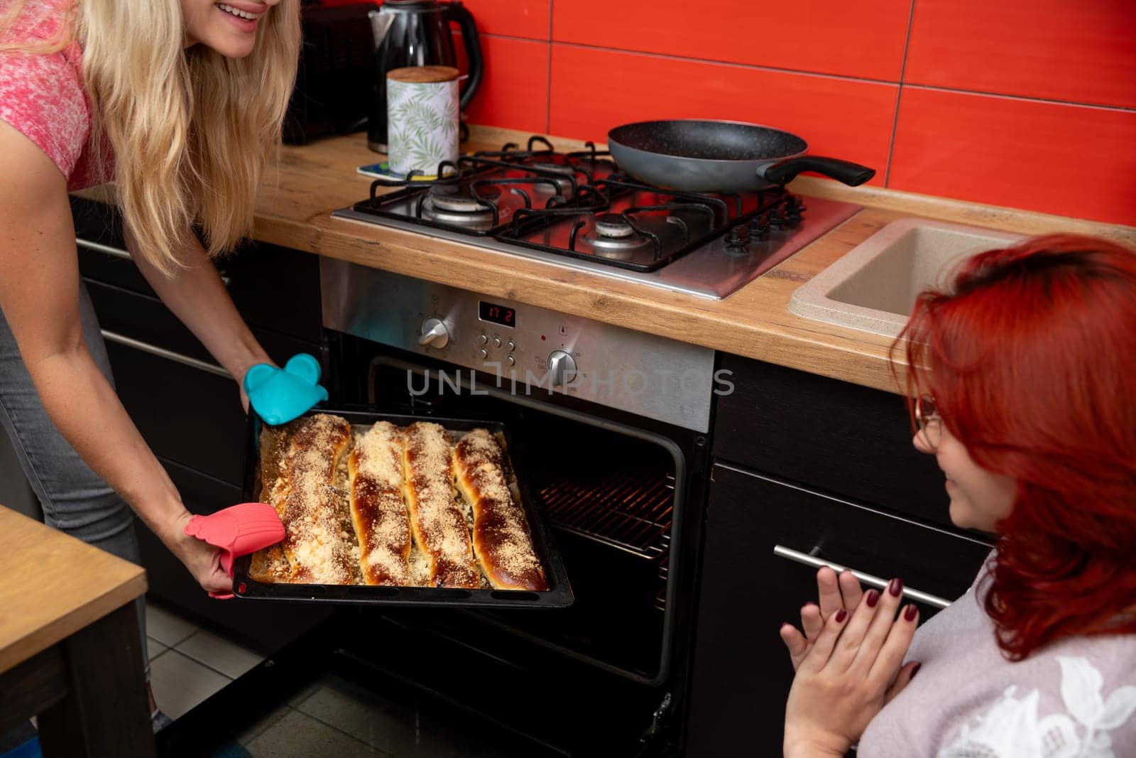 Two close friends joyfully baking together in a vibrant kitchen, happily sharing delicious moments as they create