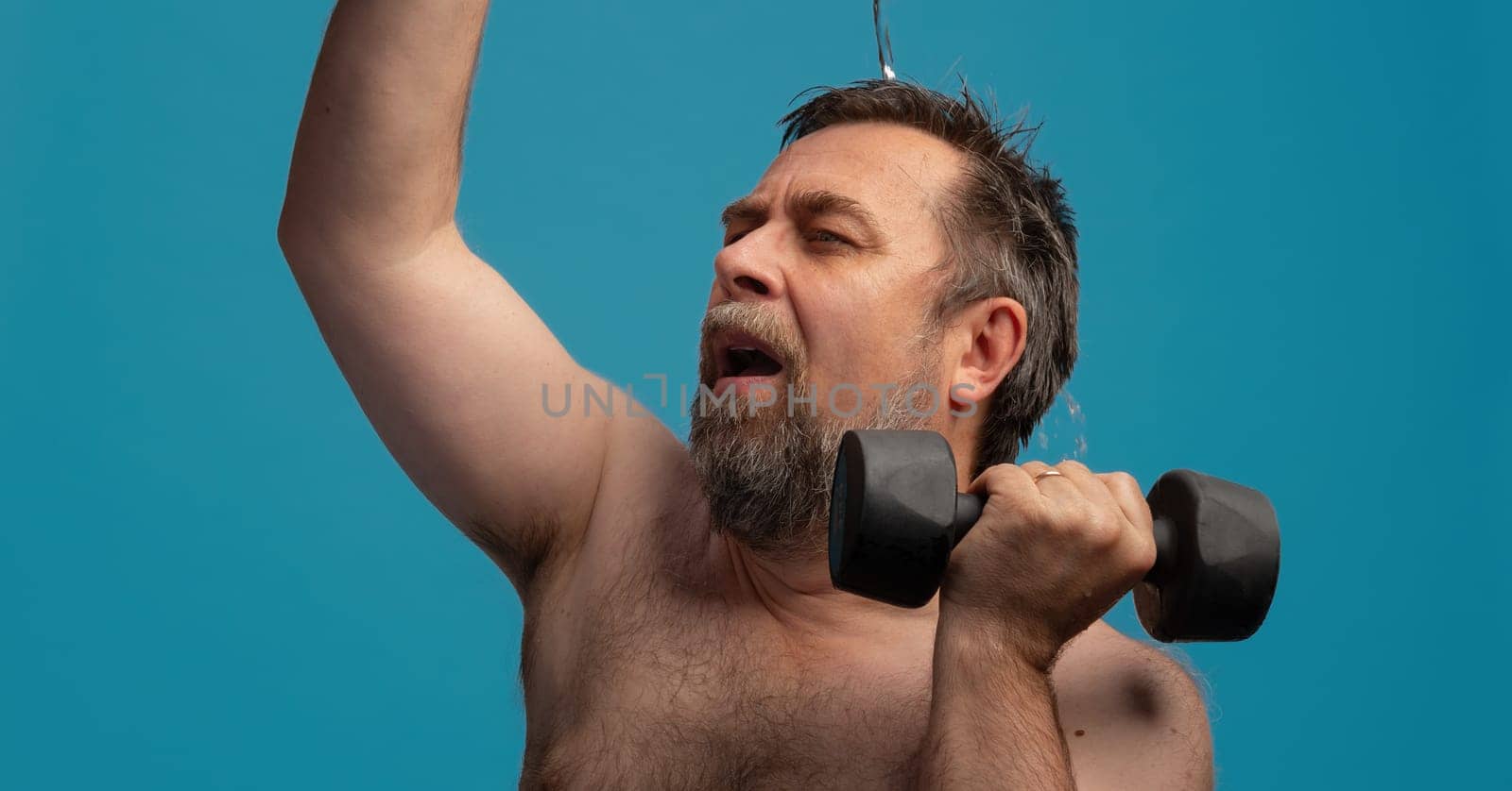 An elderly man focuses intently on his workout, lifting dumbbells with determination.