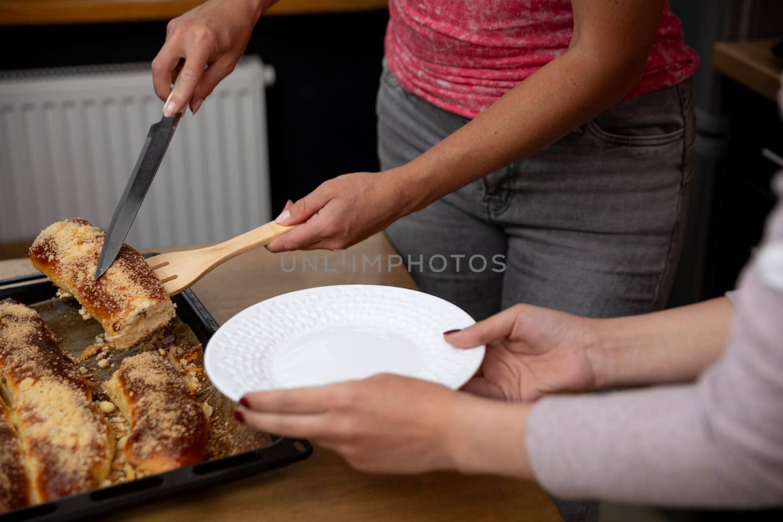 A person serves delicious enchiladas on a decorative plate in a warm, inviting kitchen filled with love