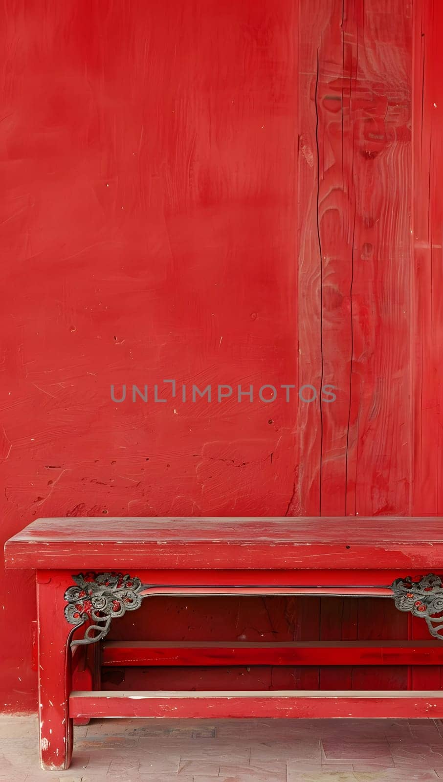 Antique red bench with intricate carvings against a vibrant red backdrop