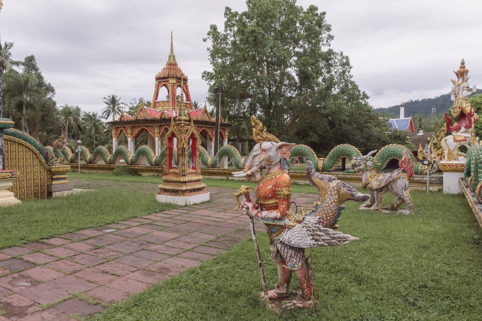Explore a serene temple garden that is beautifully adorned with vibrant statues and lush greenery all around you