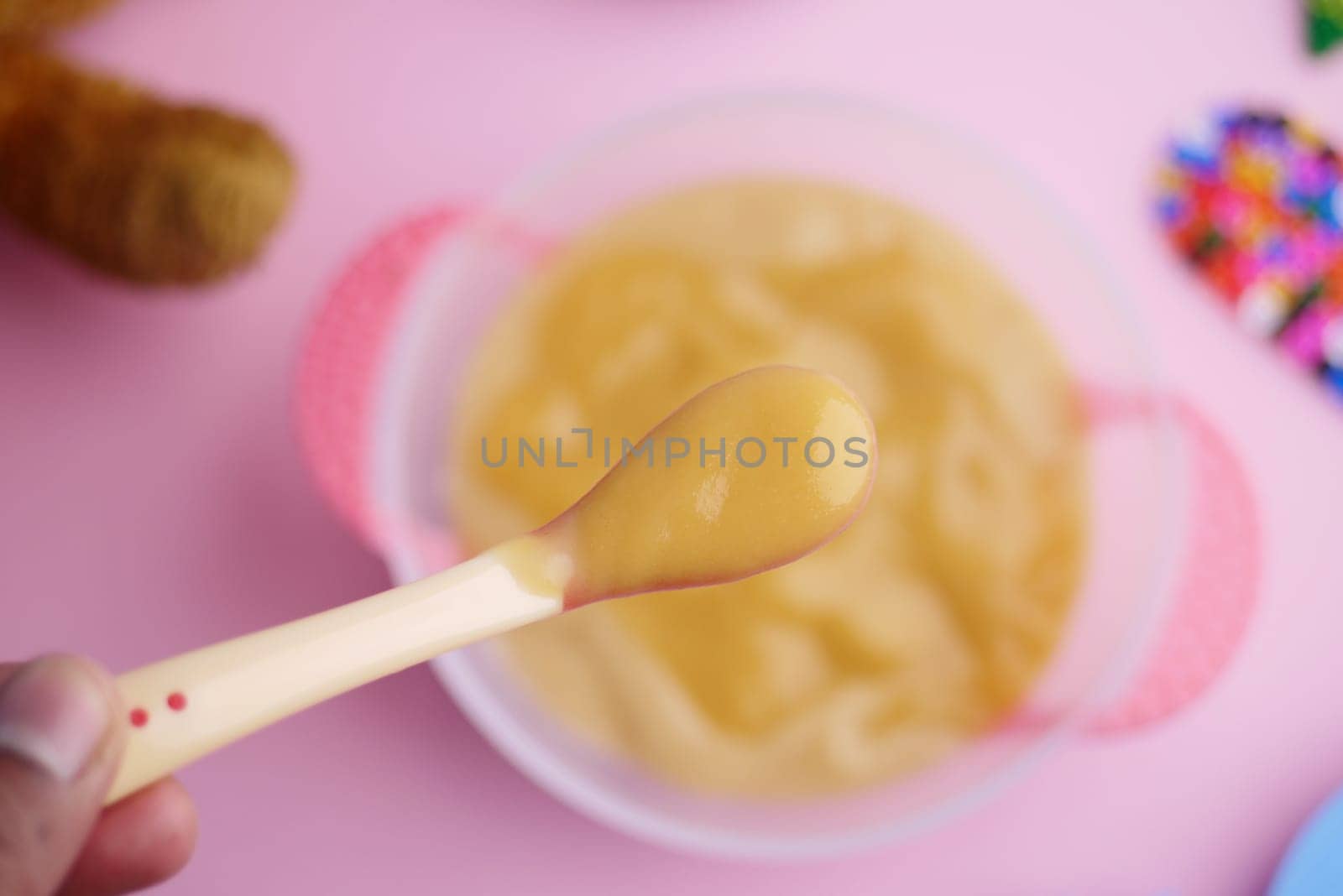 Colorful Baby Meal with Wooden Toys on Pink Background.